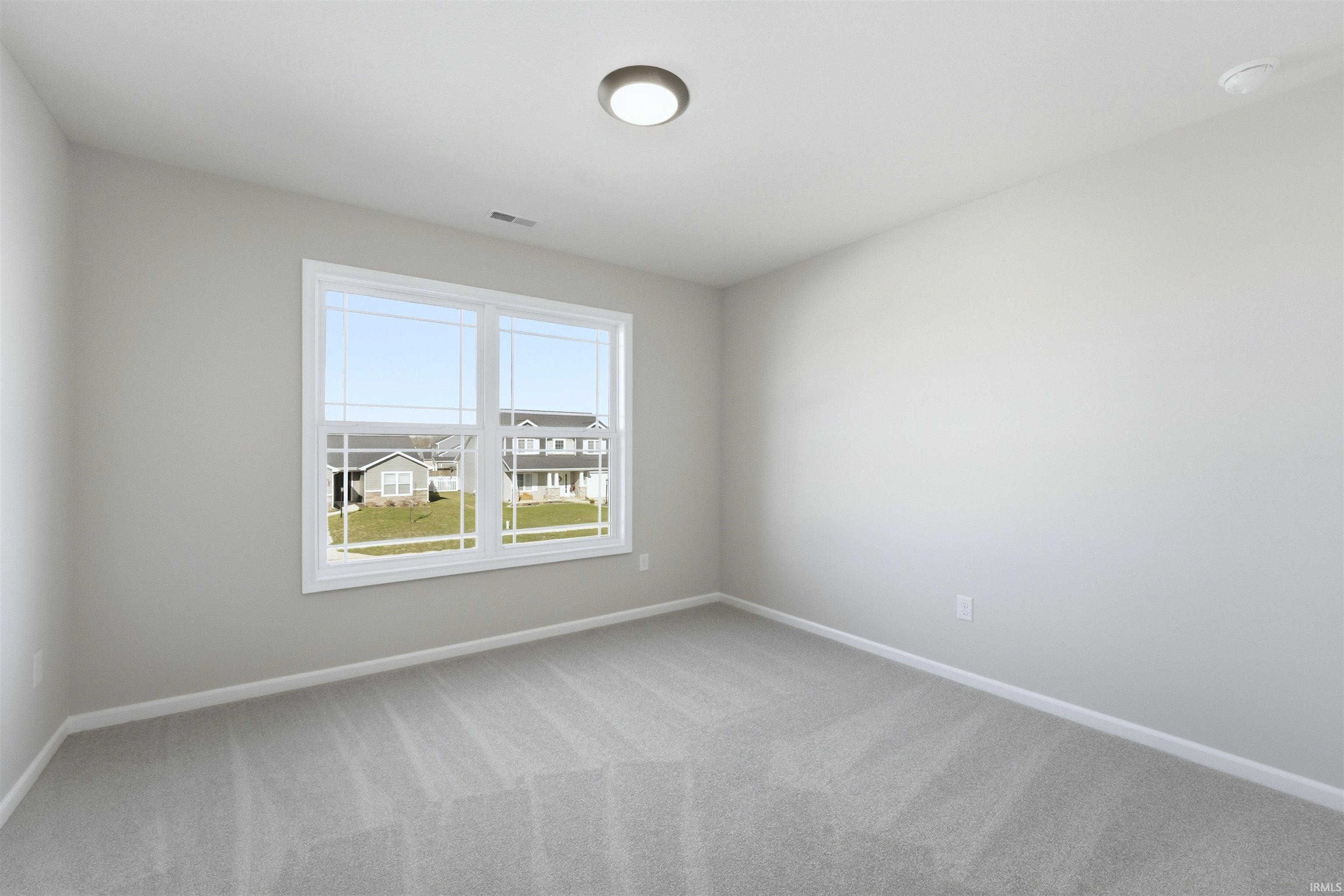 Unfurnished room featuring light carpet and baseboards