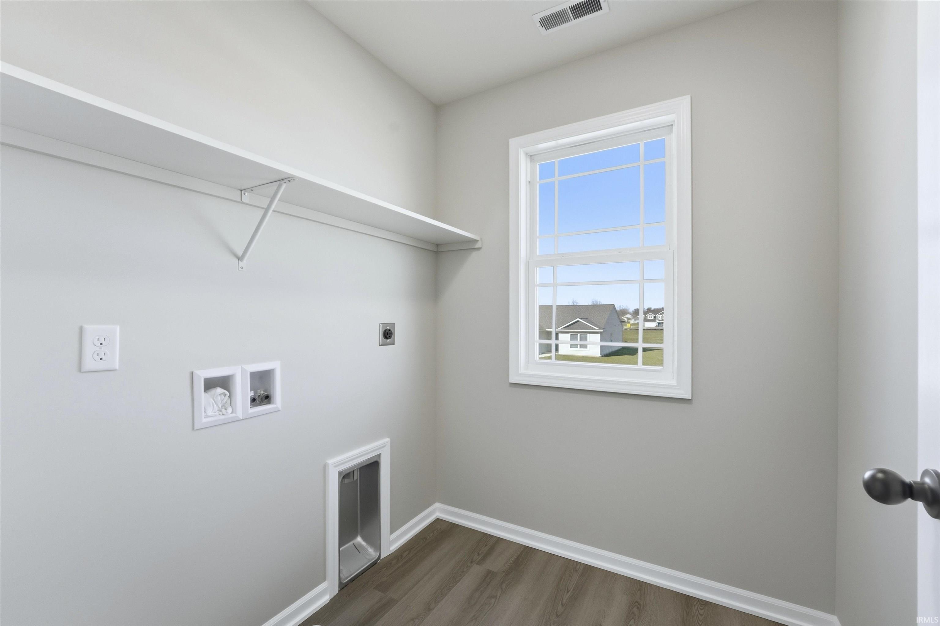Washroom featuring wood finished floors, hookup for a washing machine, and hookup for an electric dryer