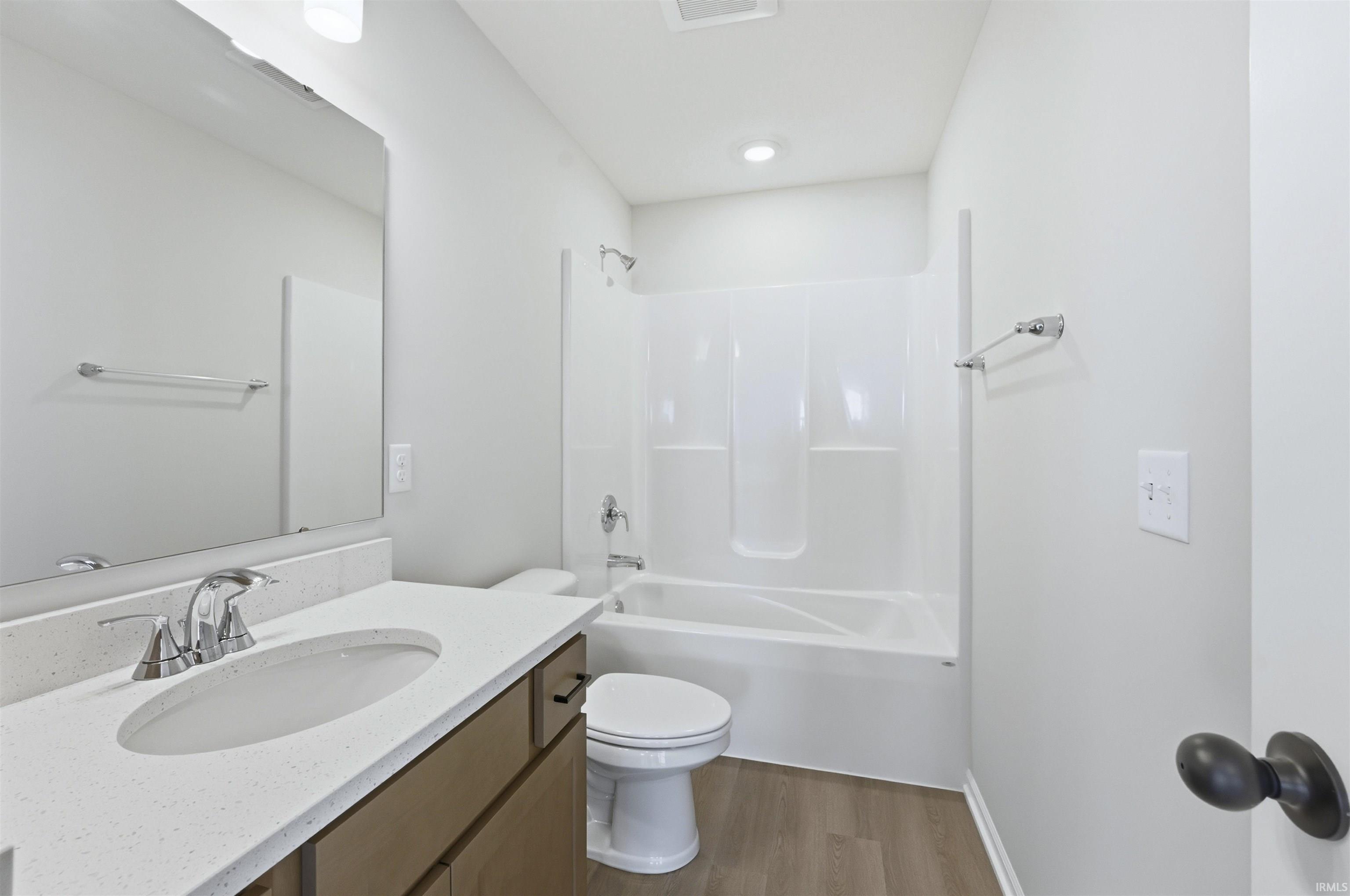 Full bathroom with vanity, light wood-style floors, and shower / bathtub combination