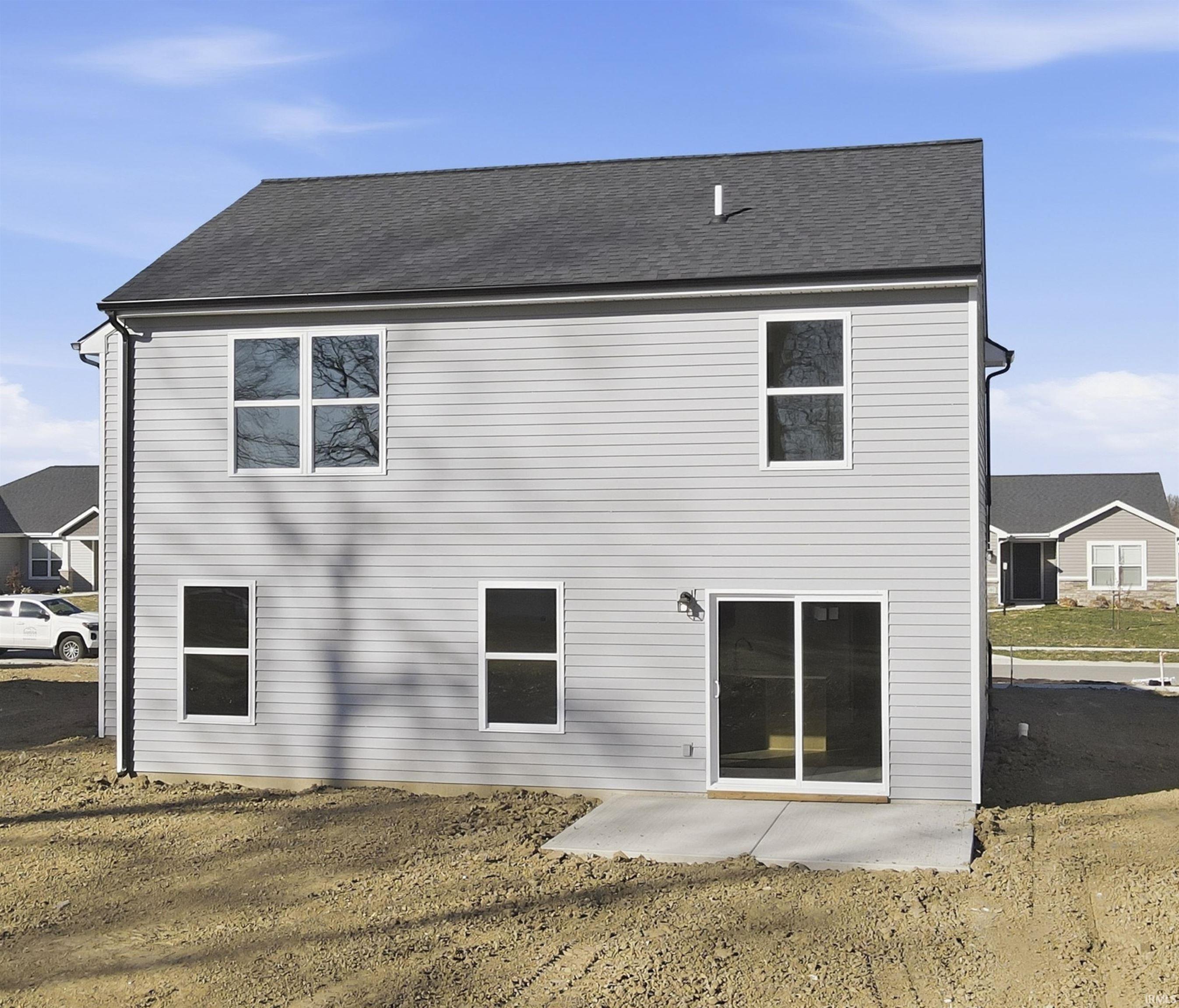 Back of house featuring a patio area and a shingled roof