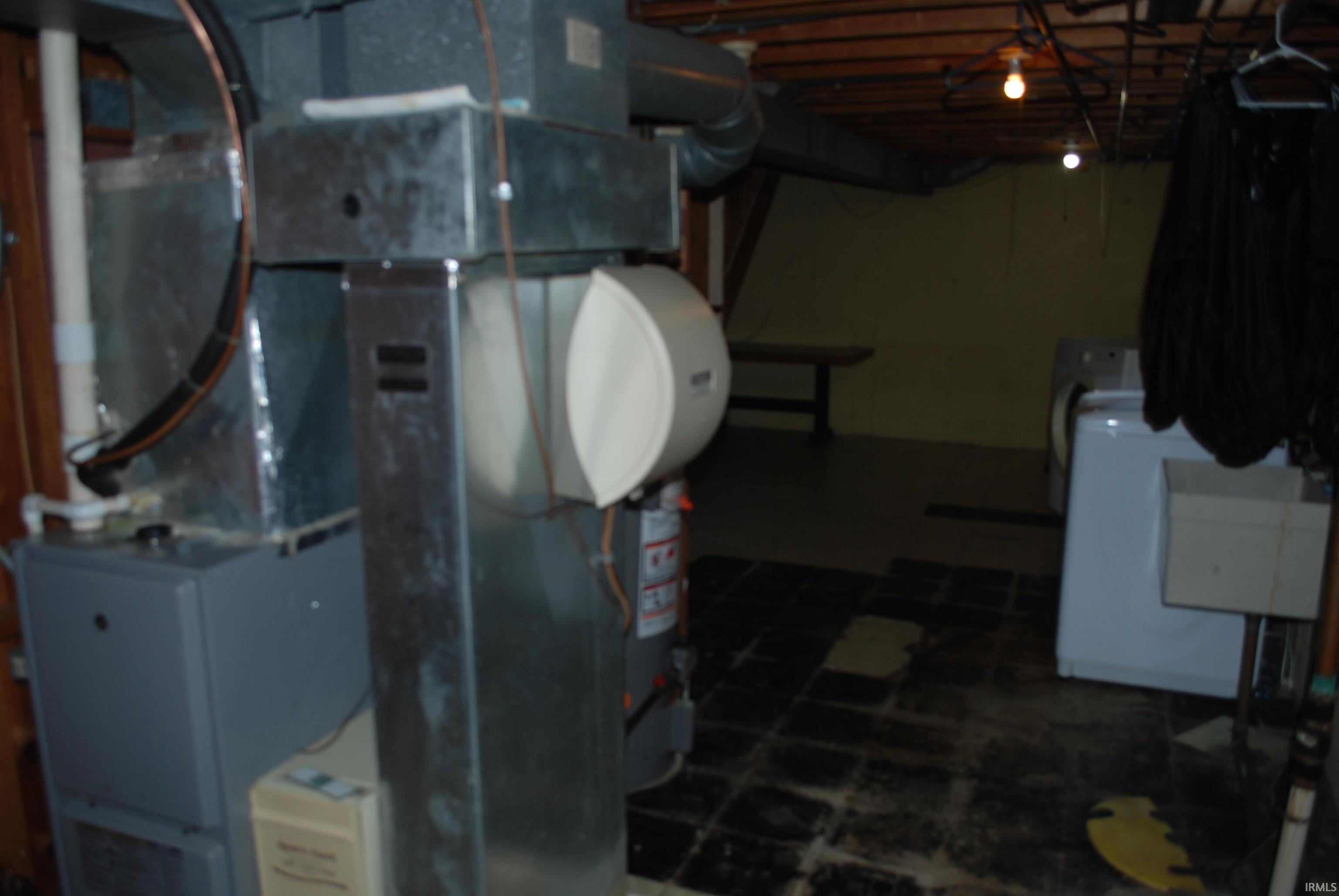 Unfinished below grade area featuring heating unit and washer / clothes dryer