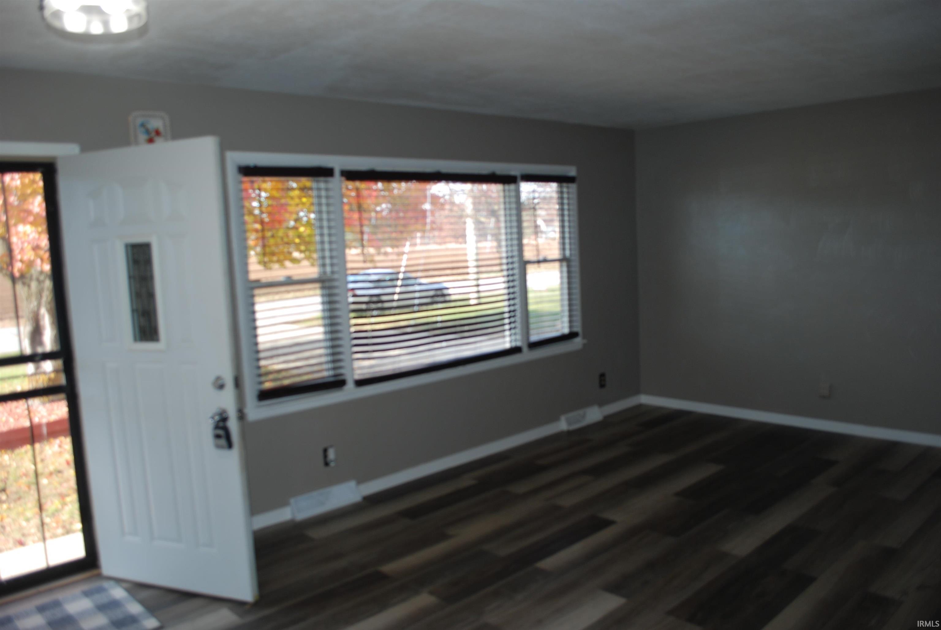 Entrance foyer with baseboards and dark wood-style floors