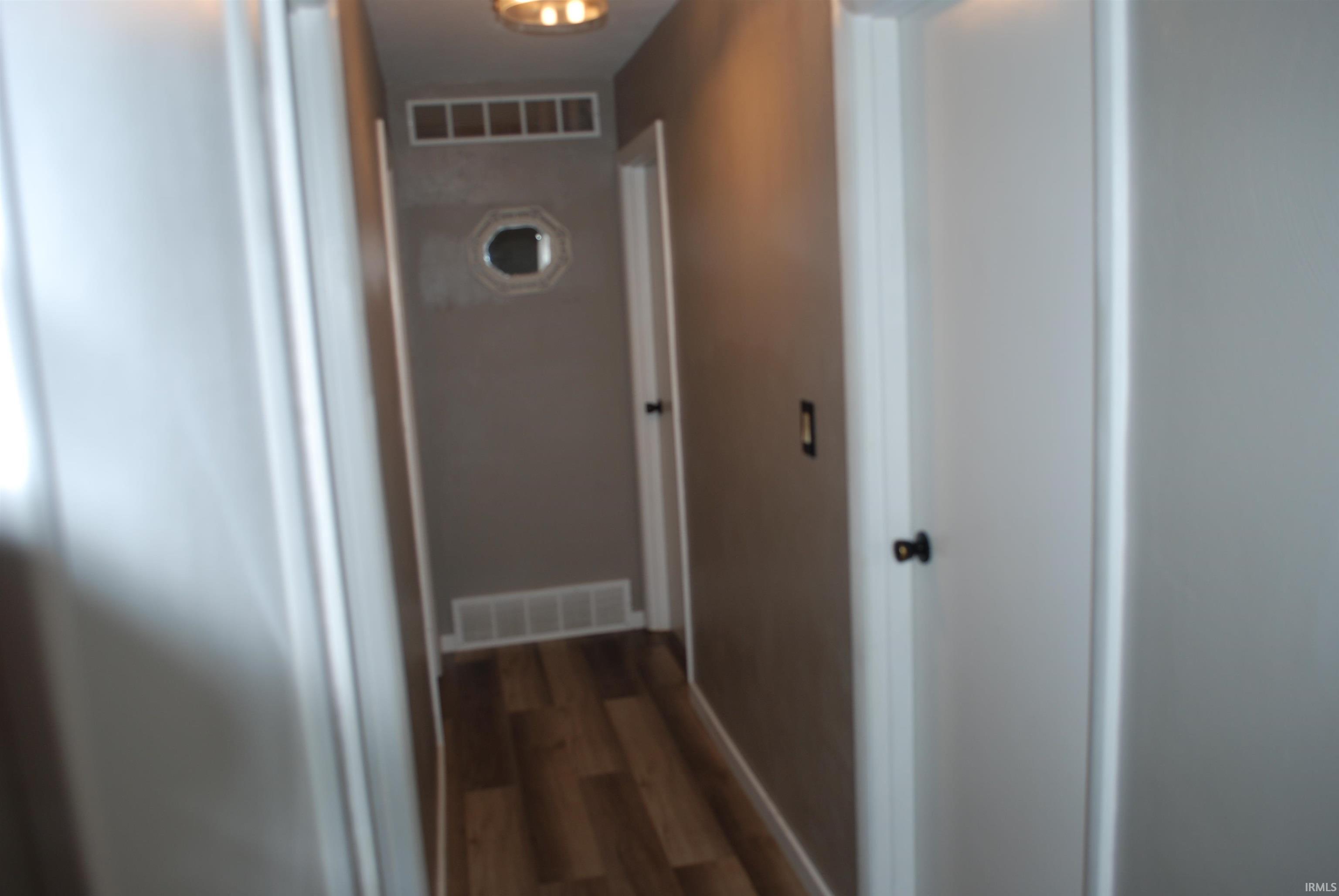 Hallway featuring dark wood-style flooring