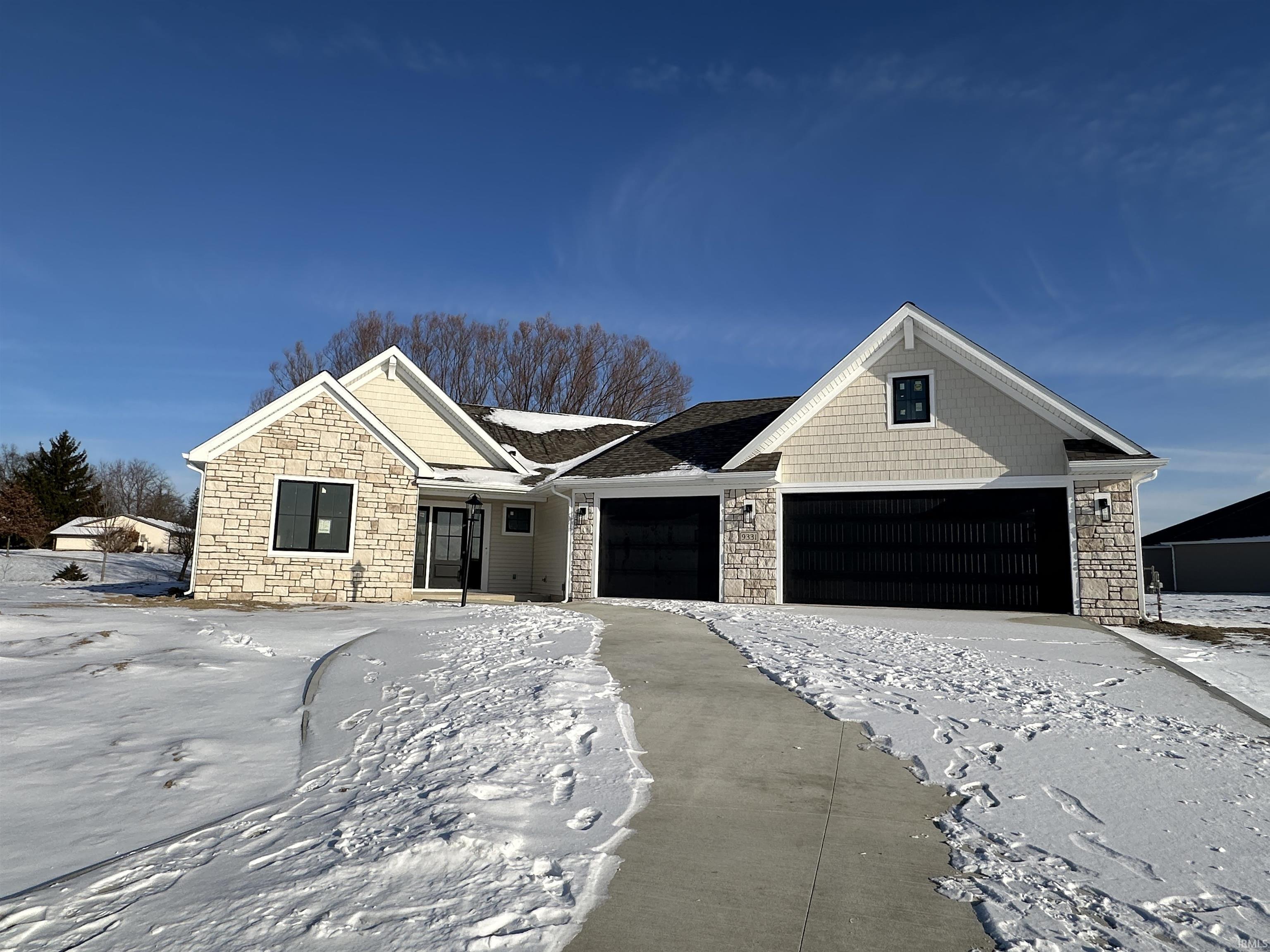 View of front of house with stone siding and an attached garage