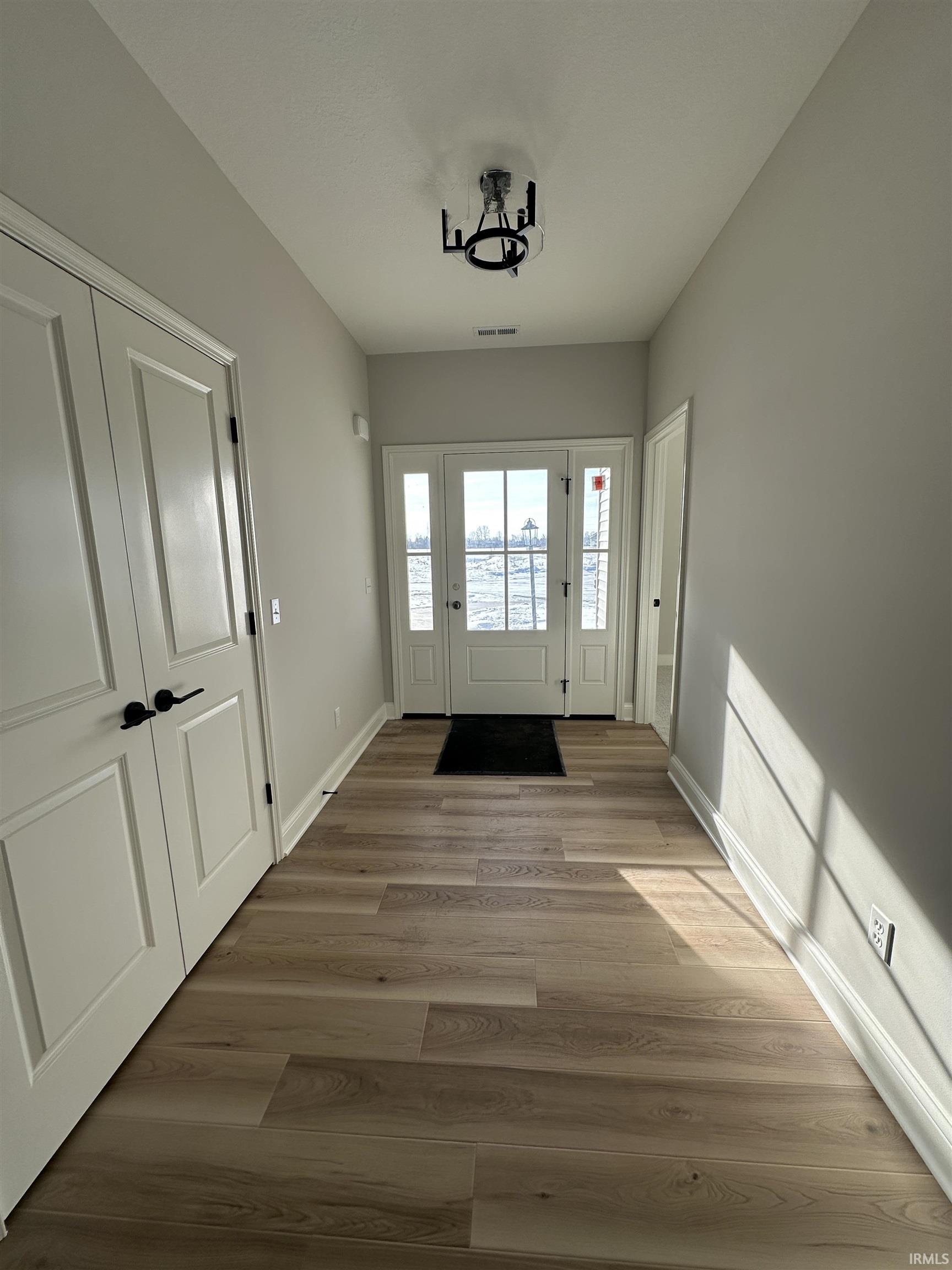 Entrance foyer with wood finished floors and baseboards