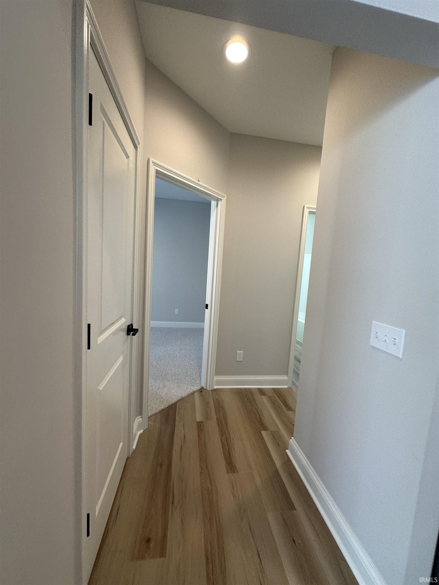 Hall with wood finished floors and recessed lighting