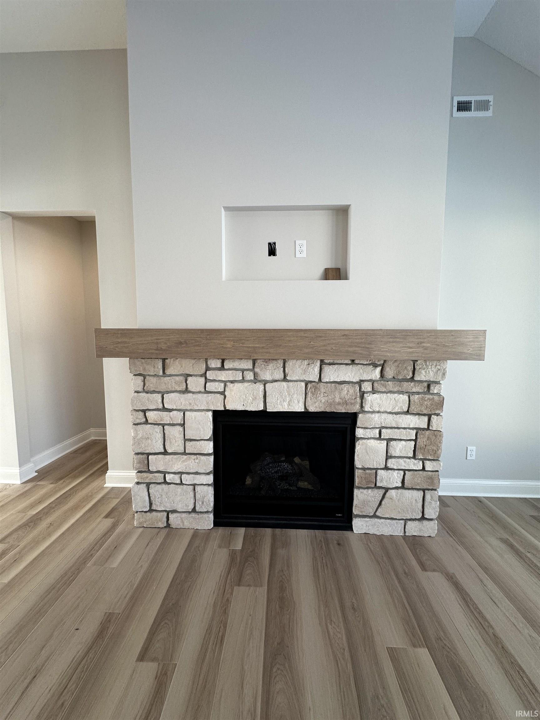 Detailed view of a fireplace and wood finished floors