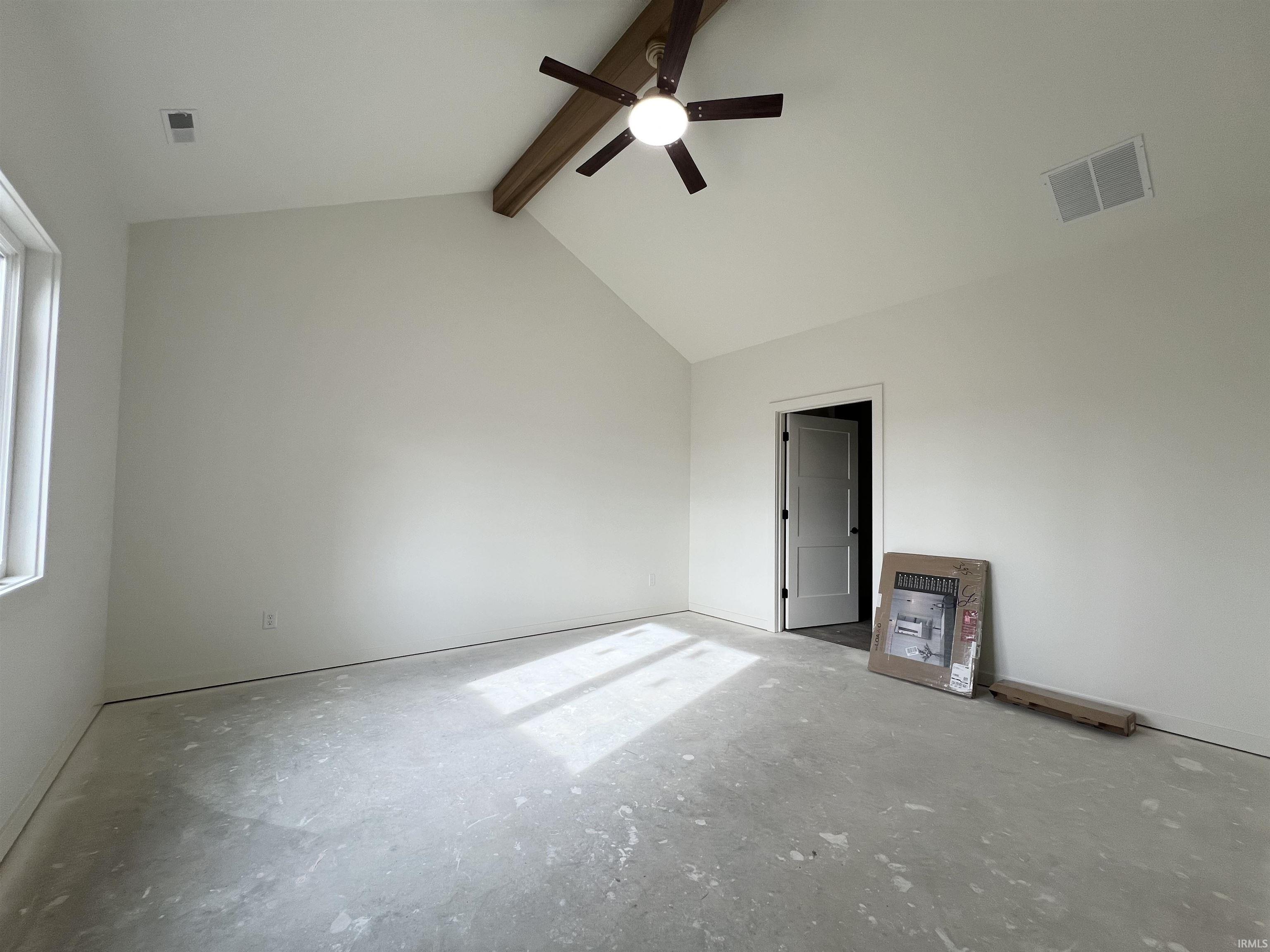 Empty room featuring ceiling fan, beam ceiling, heating unit, concrete flooring, and high vaulted ceiling