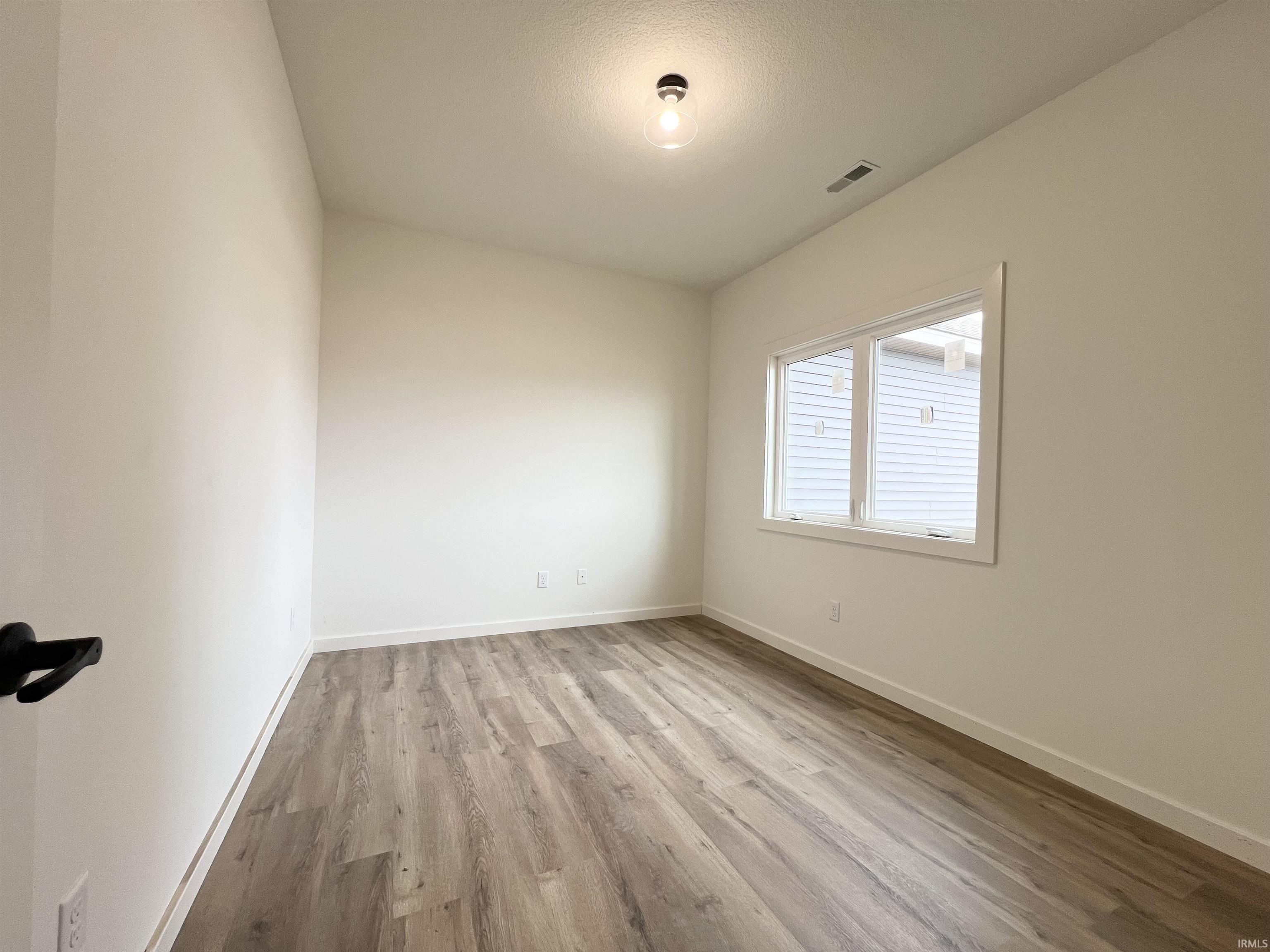 Empty room featuring light wood-type flooring and baseboards