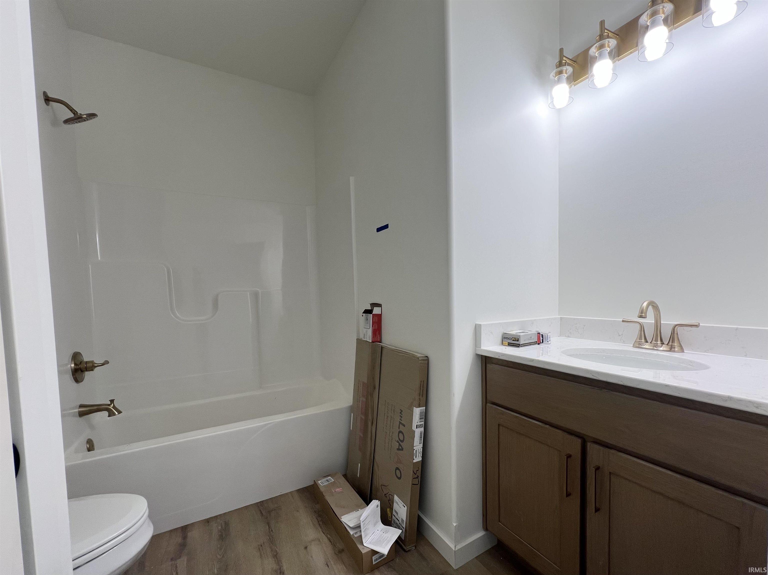 Bathroom featuring vanity, dark wood-style floors, and  shower combination