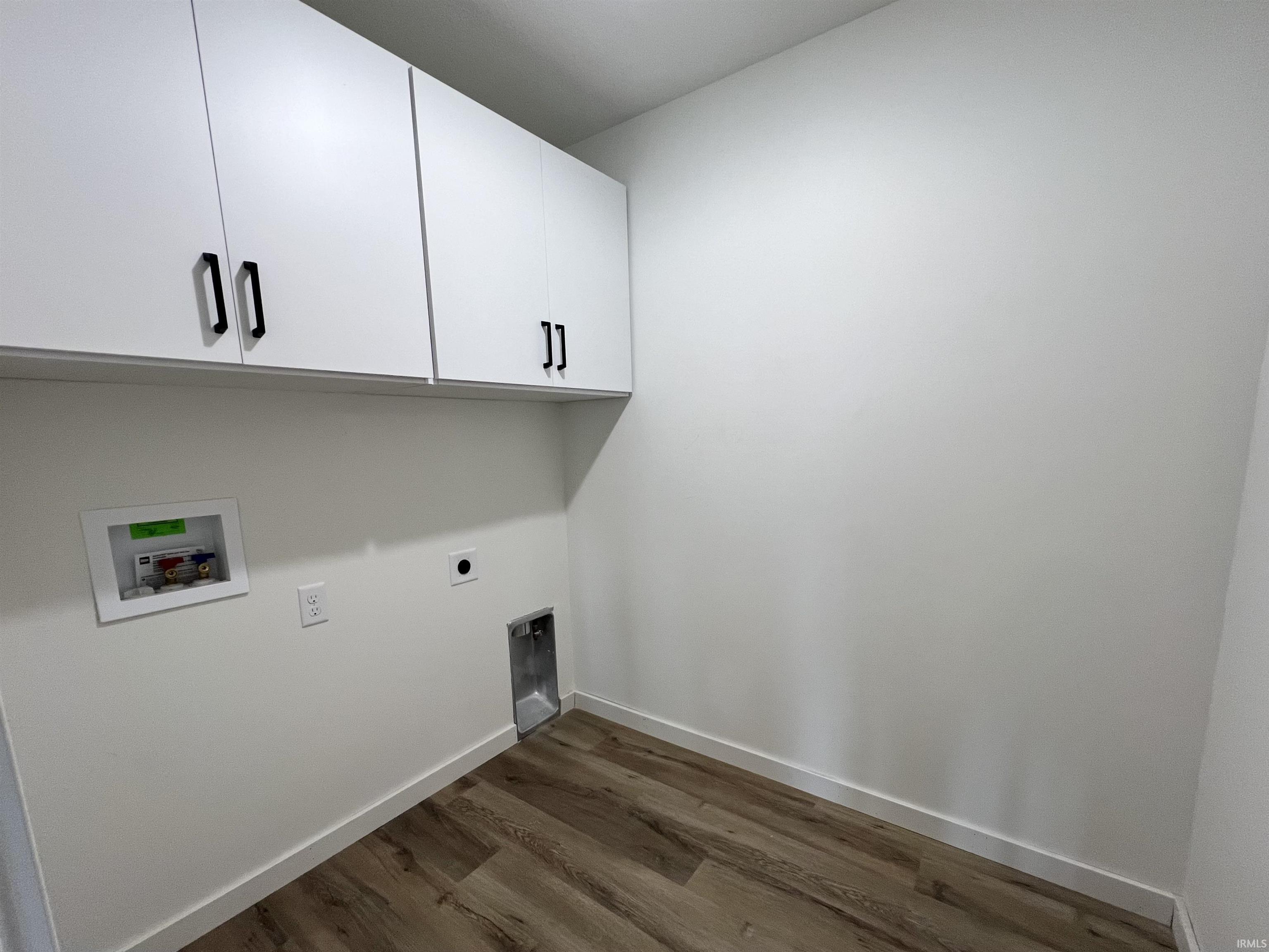 Laundry area with cabinet space, dark wood finished floors, washer hookup, and electric dryer hookup