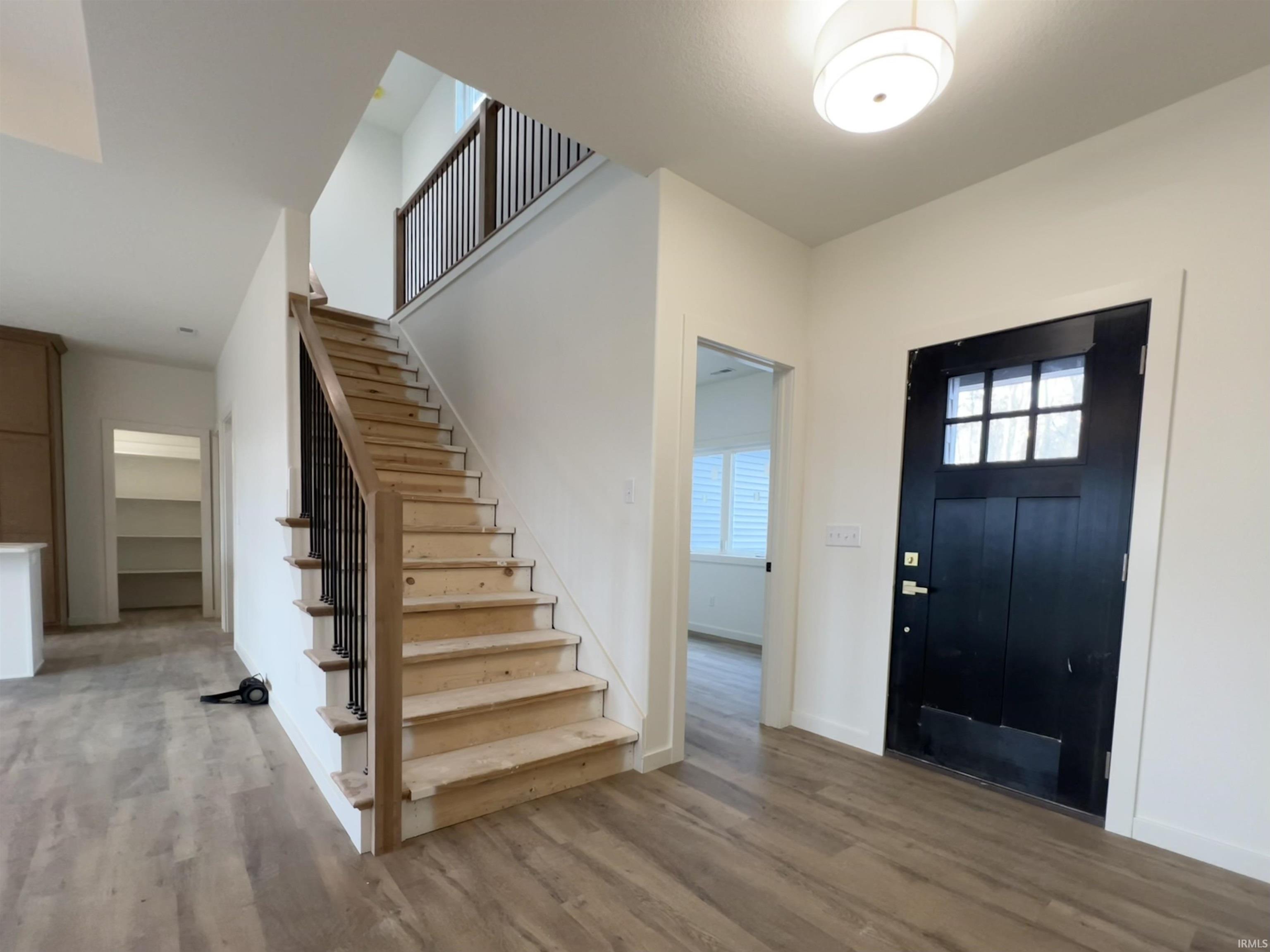 Foyer featuring stairway and light wood finished floors
