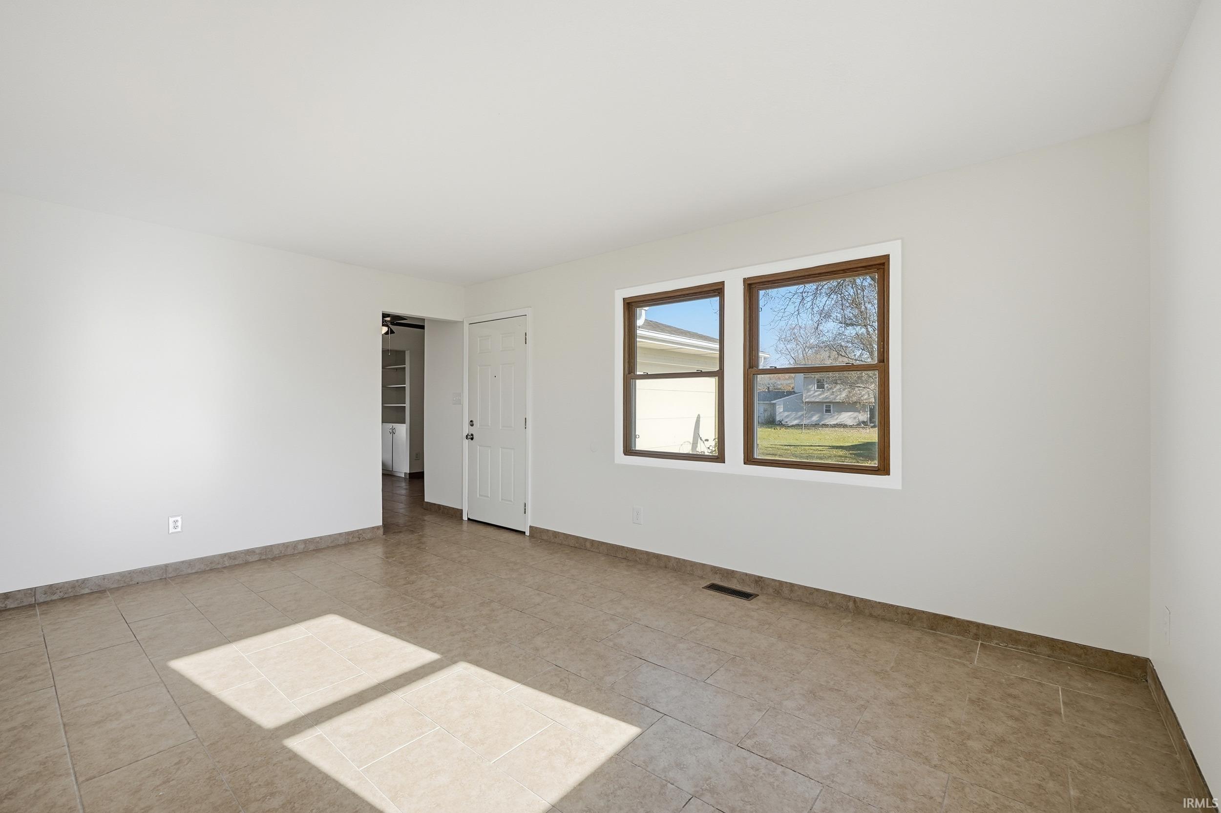 Spare room with baseboards and light tile patterned floors