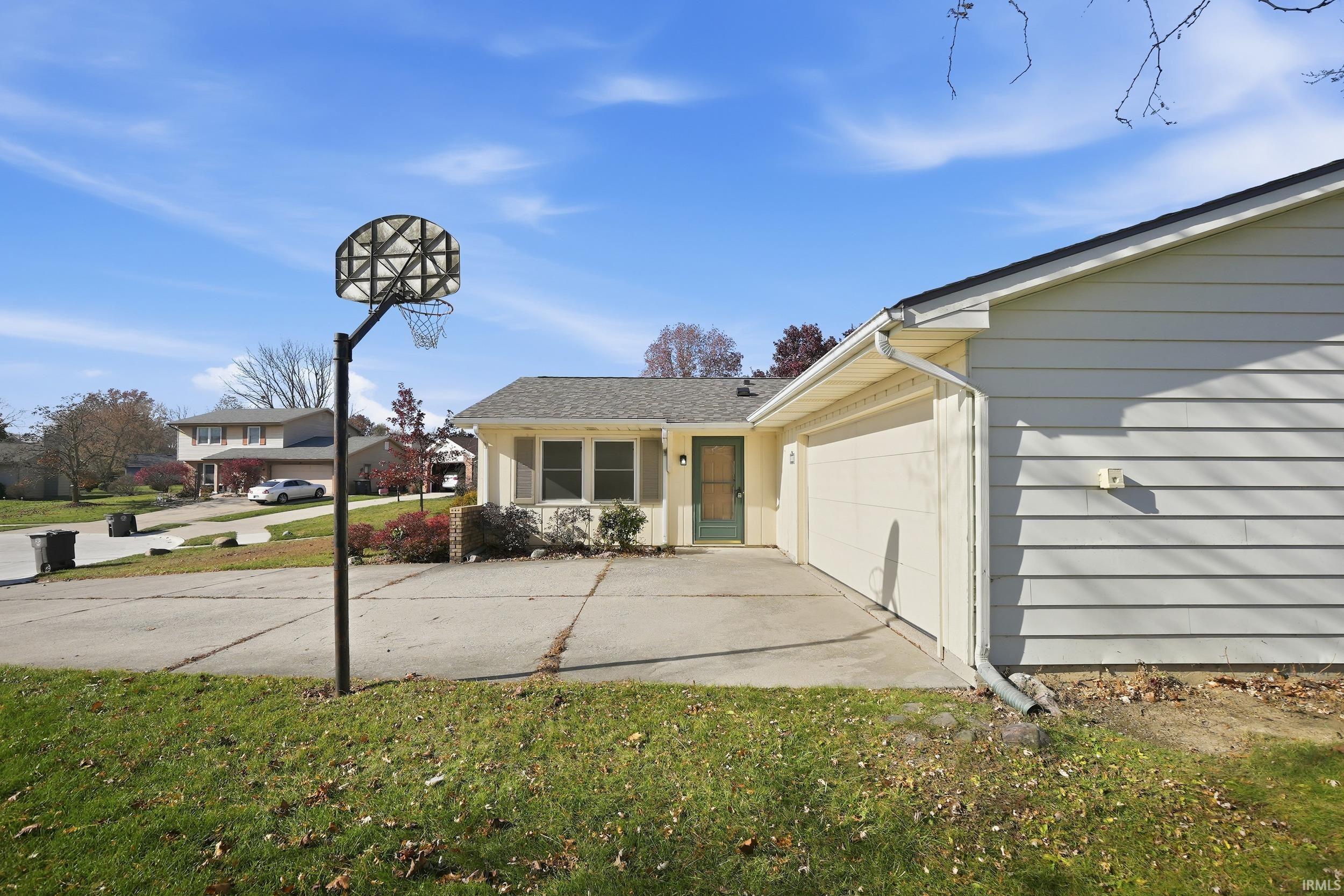 View of front of property with driveway, a front lawn, and a garage