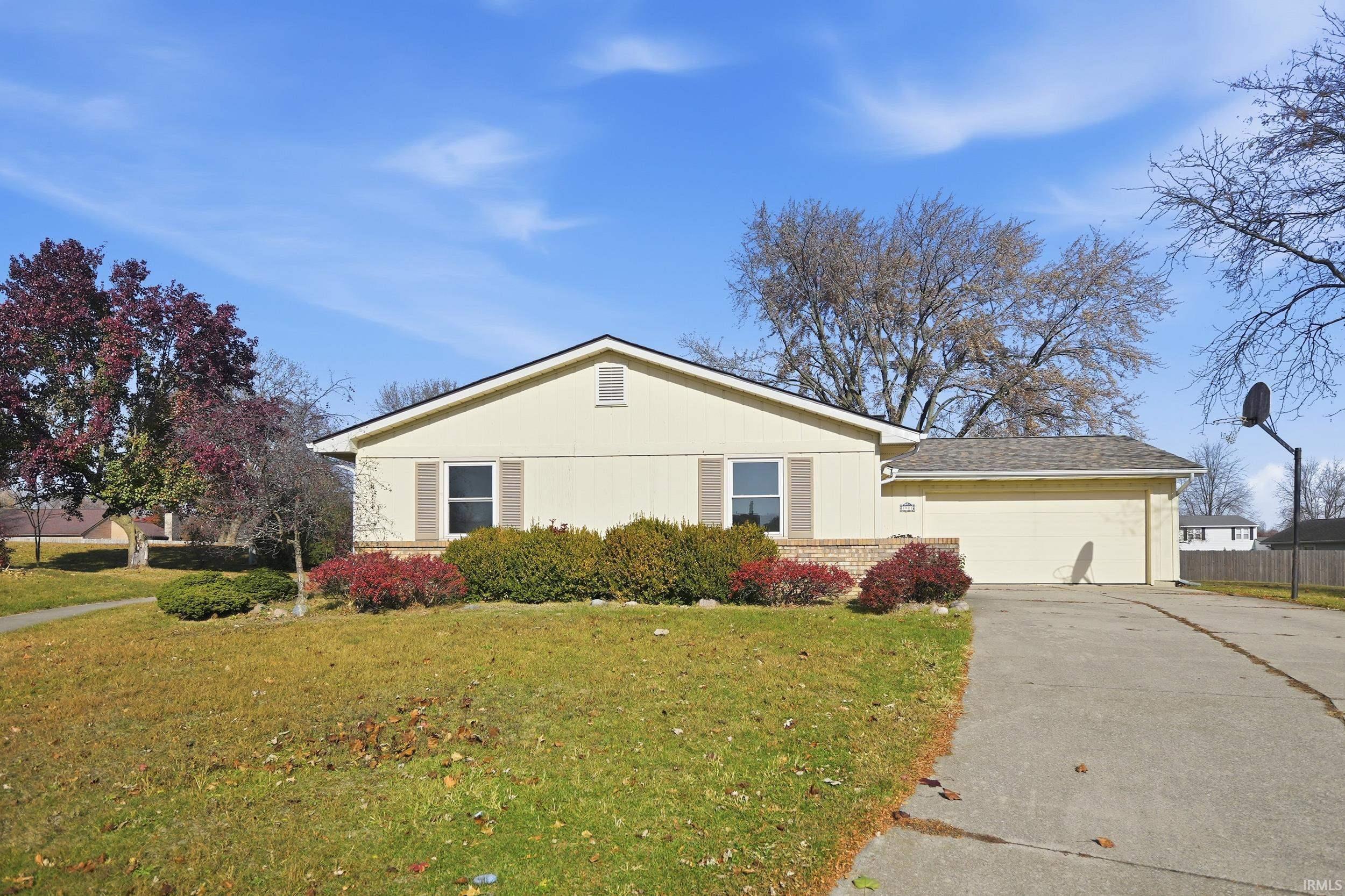 View of front of house featuring concrete driveway, a garage, and brick siding