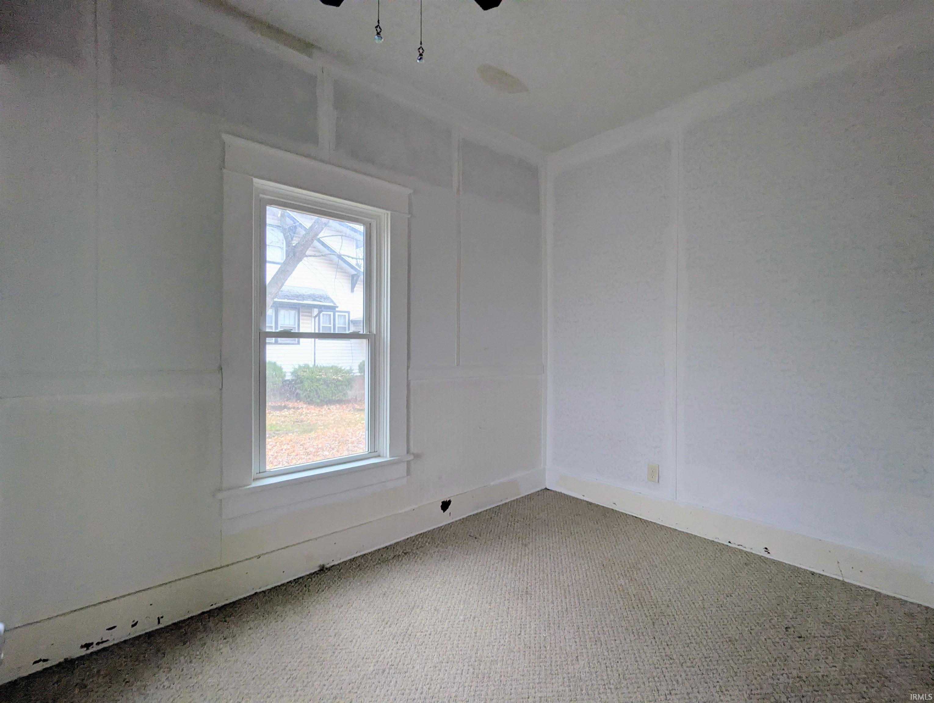 Carpeted empty room with a decorative wall and a ceiling fan