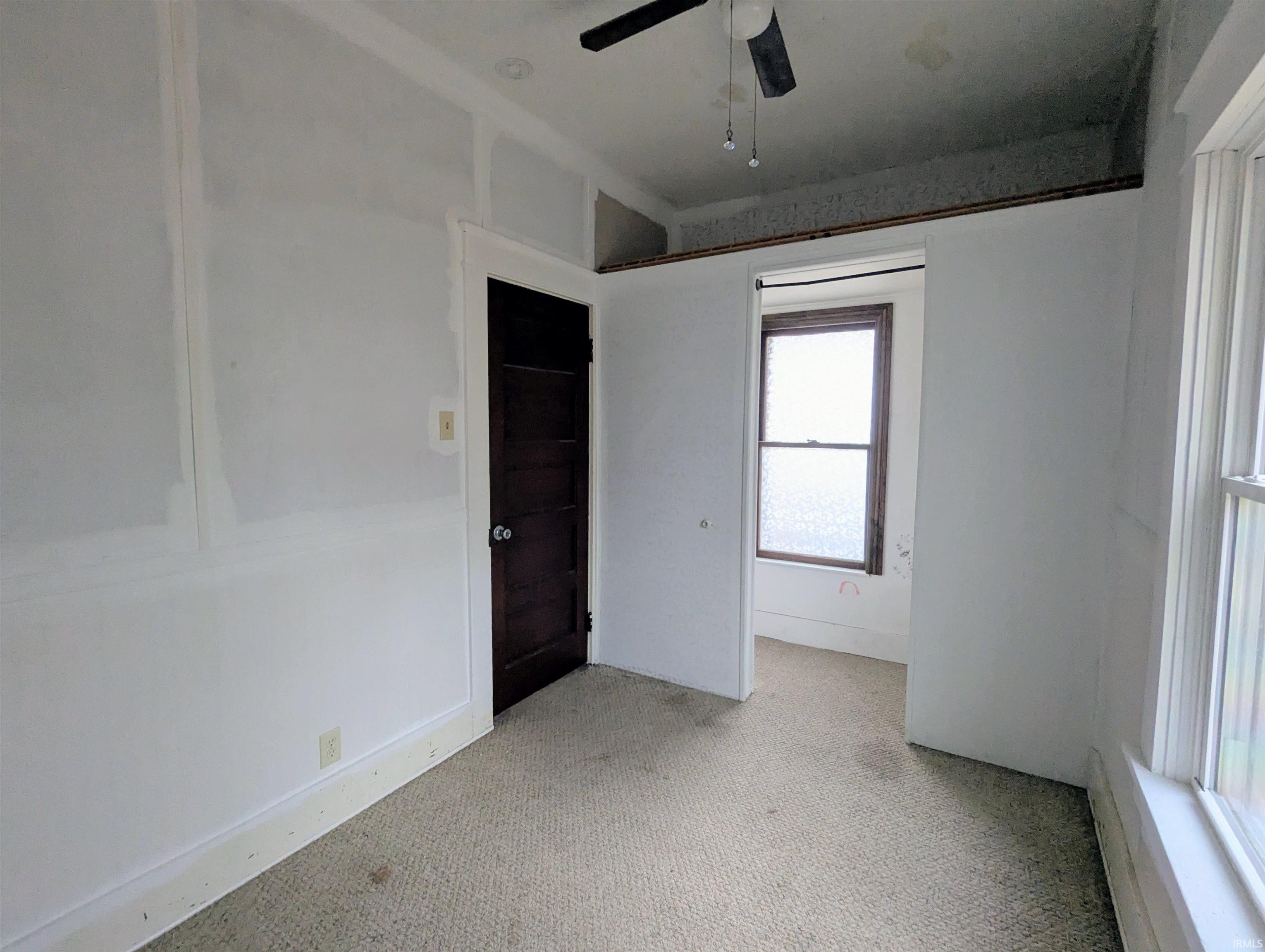 Empty room featuring light carpet and ceiling fan