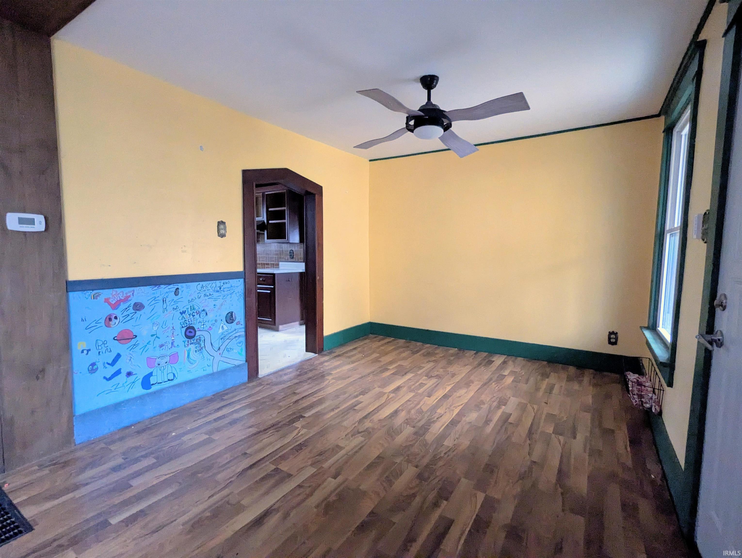 Spare room with dark wood-style flooring and a ceiling fan