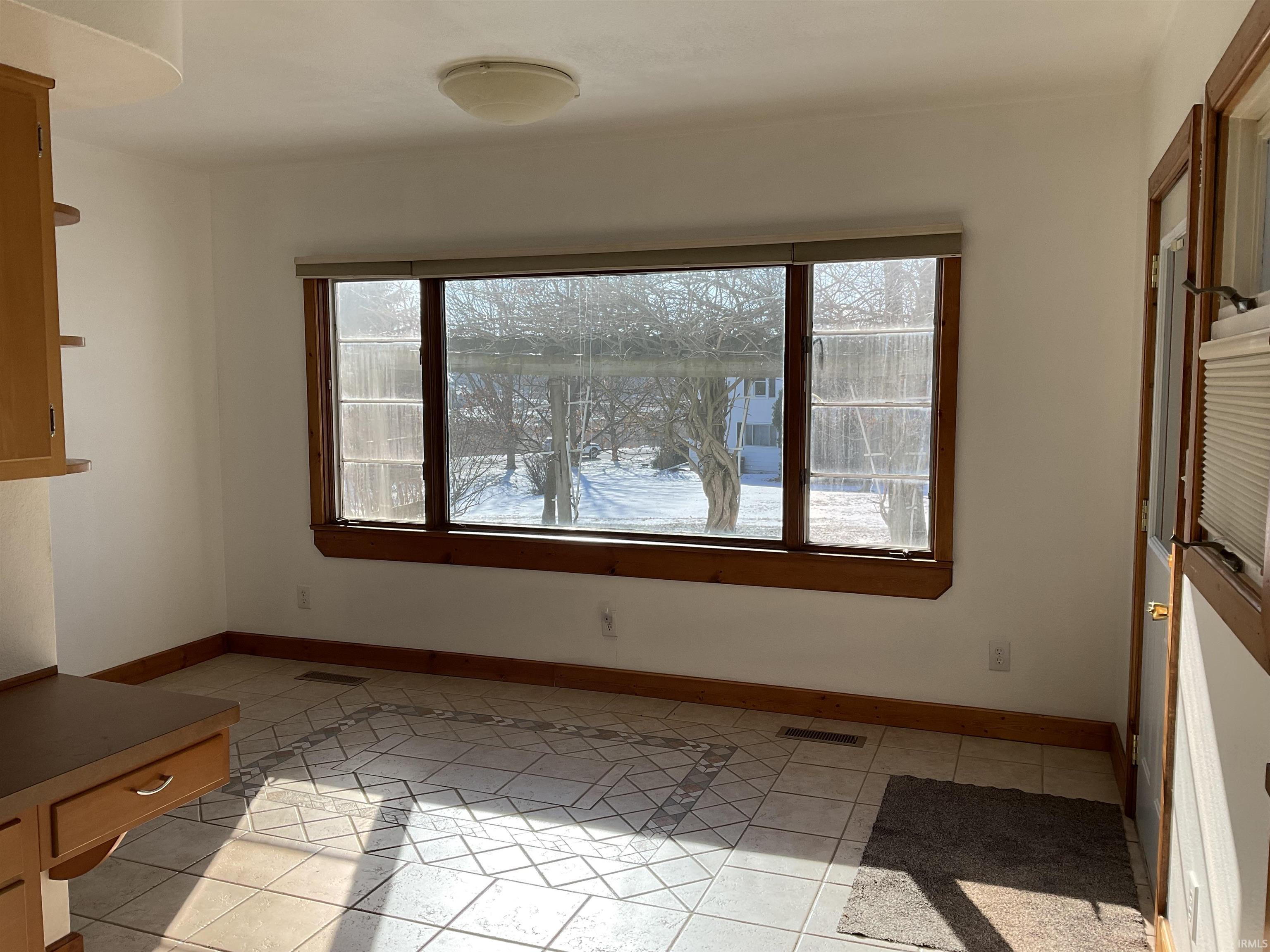 Dining area with light tile patterned floors and healthy amount of natural light