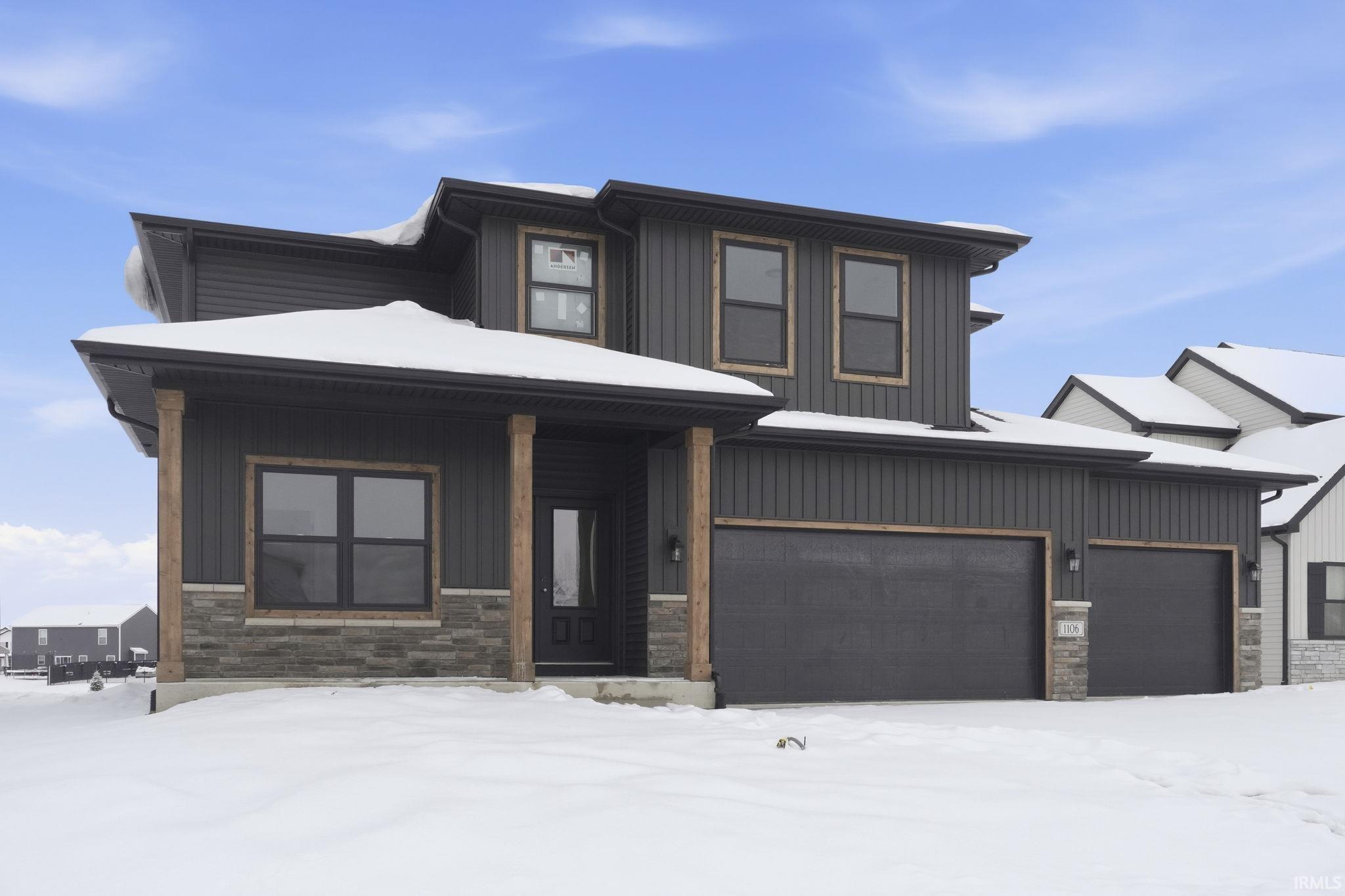 View of front of house featuring stone siding, a porch, and board and batten siding