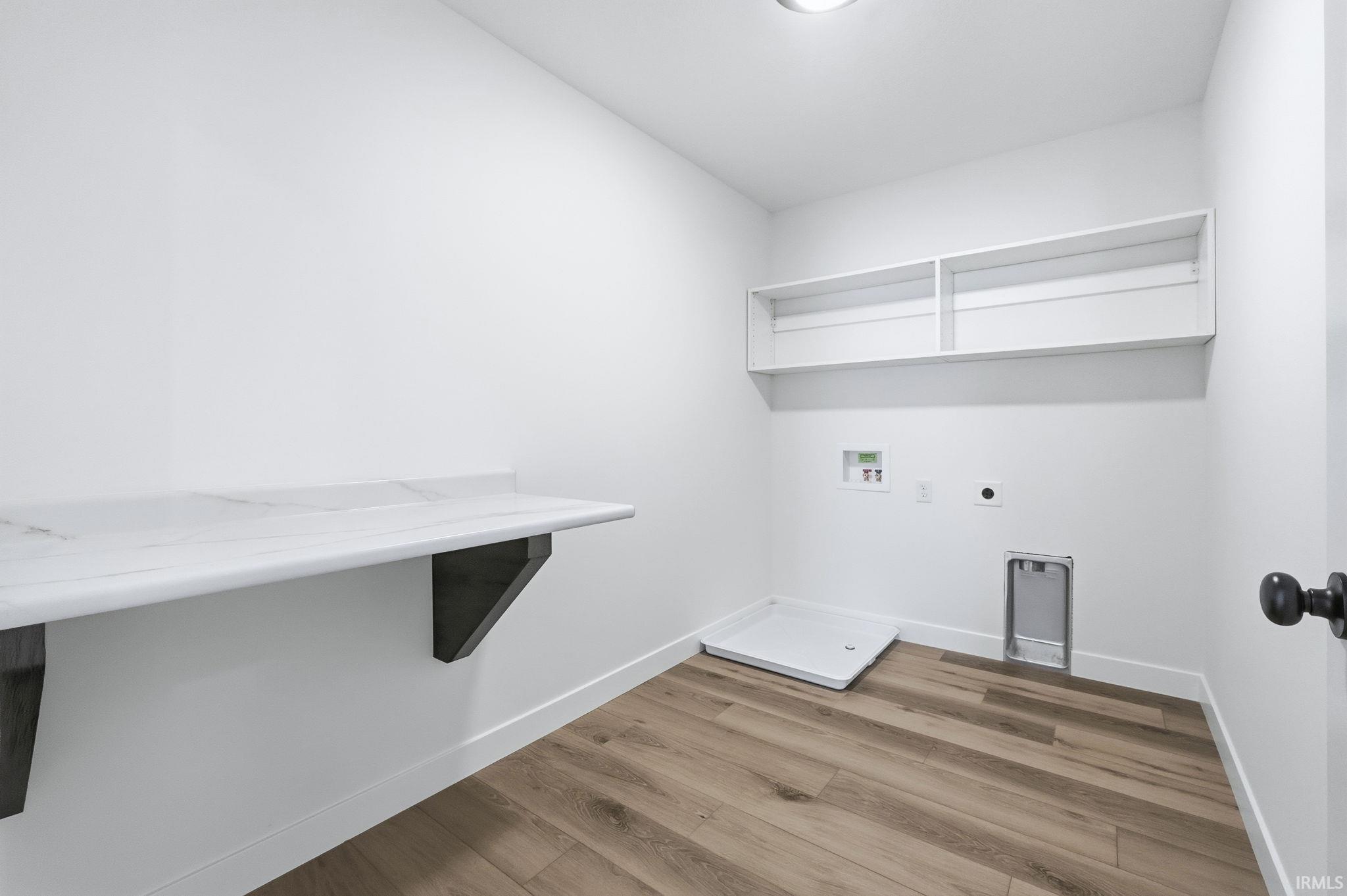 Laundry room featuring light wood finished floors, hookup for a washing machine, and electric dryer hookup