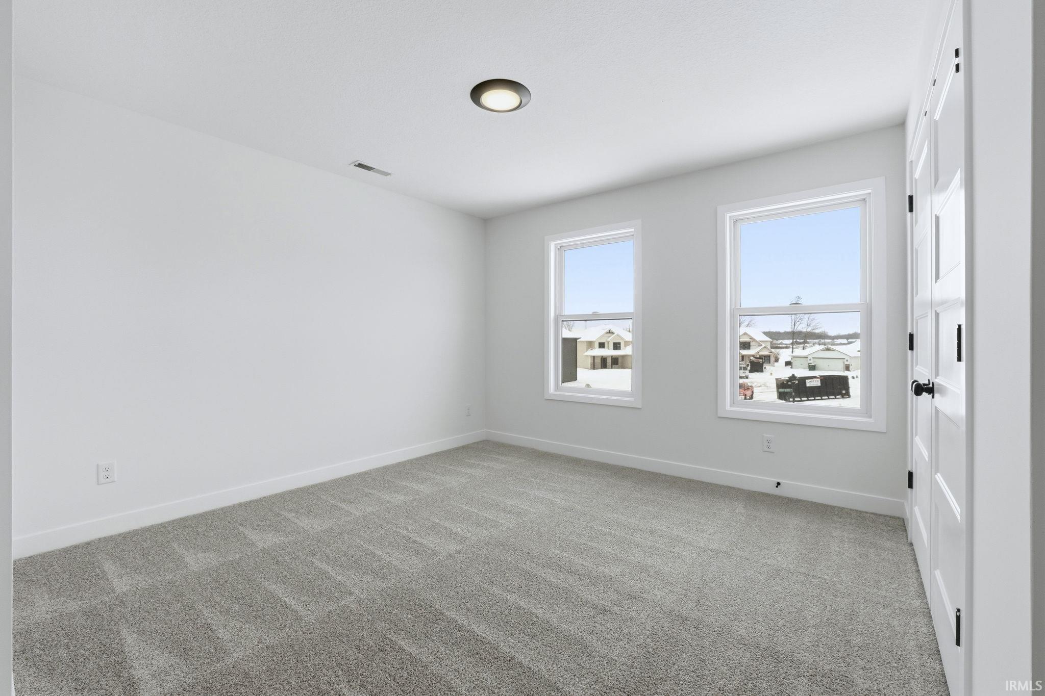 Unfurnished room featuring light colored carpet and baseboards