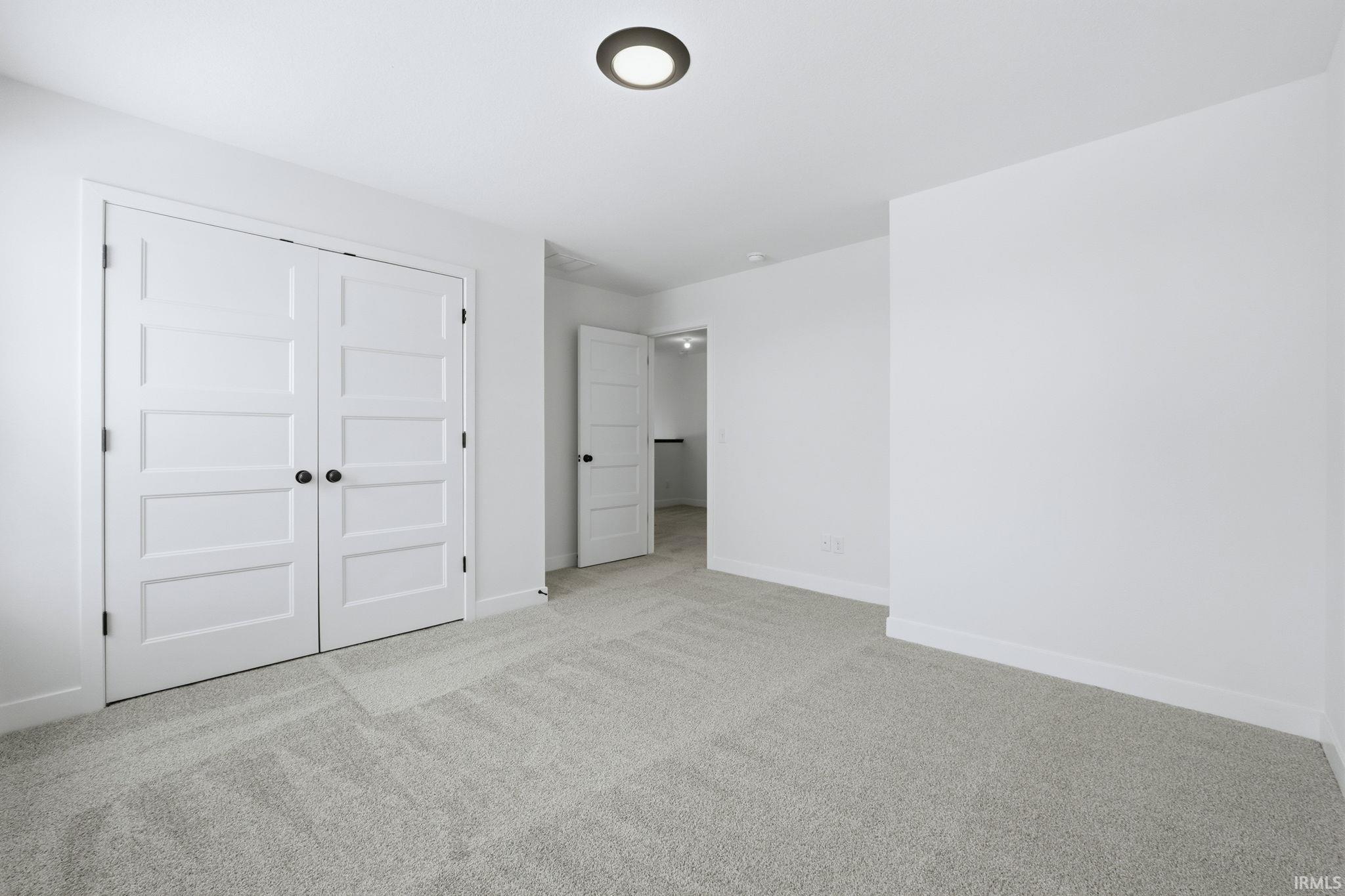 Unfurnished bedroom with carpet and a closet