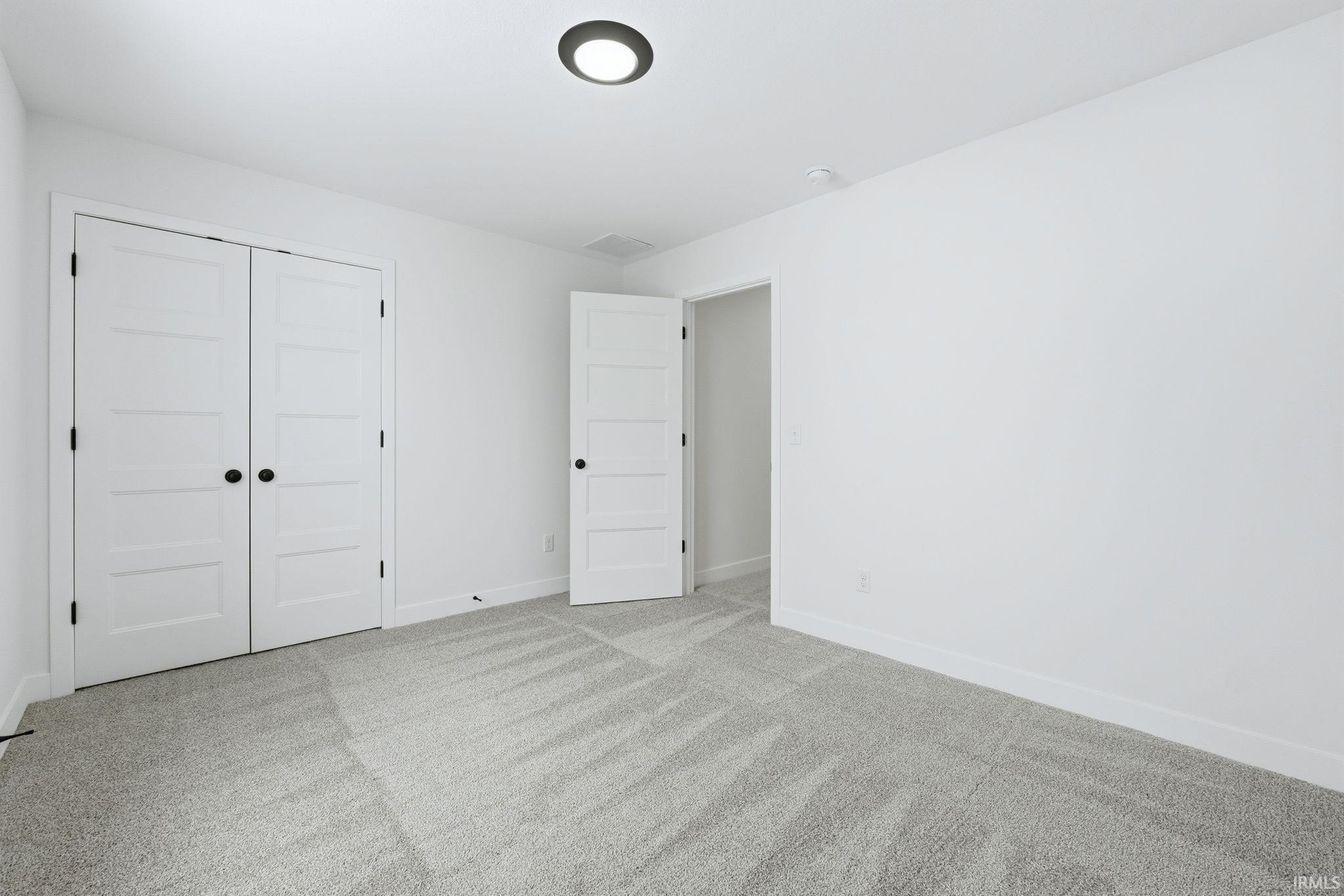 Unfurnished bedroom with carpet and a closet