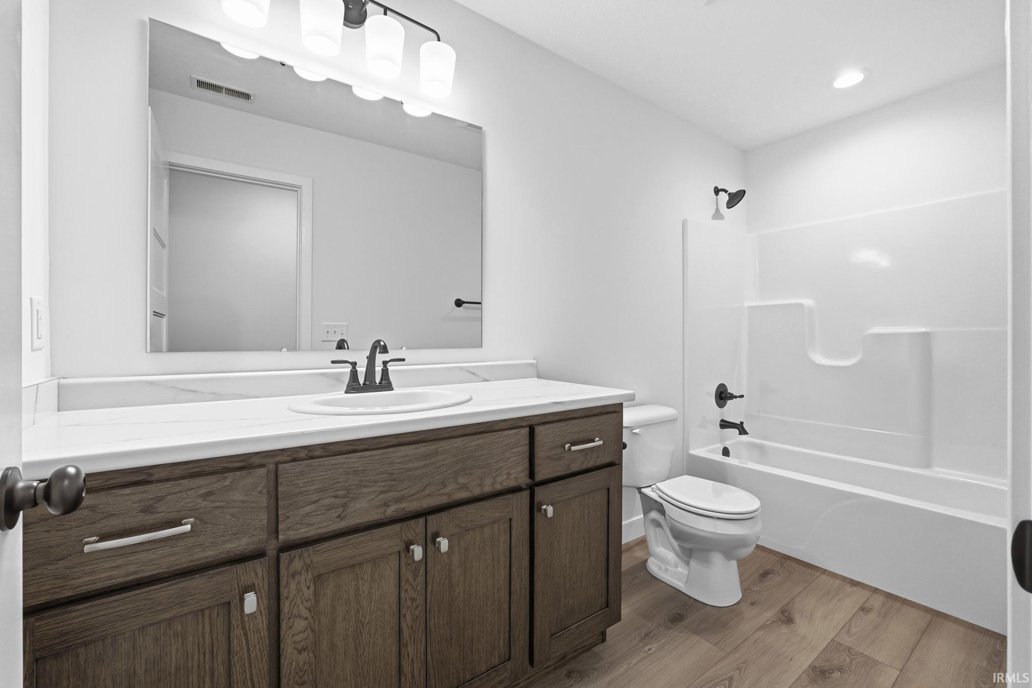 Full bath with vanity, light wood-style floors, and bathing tub / shower combination