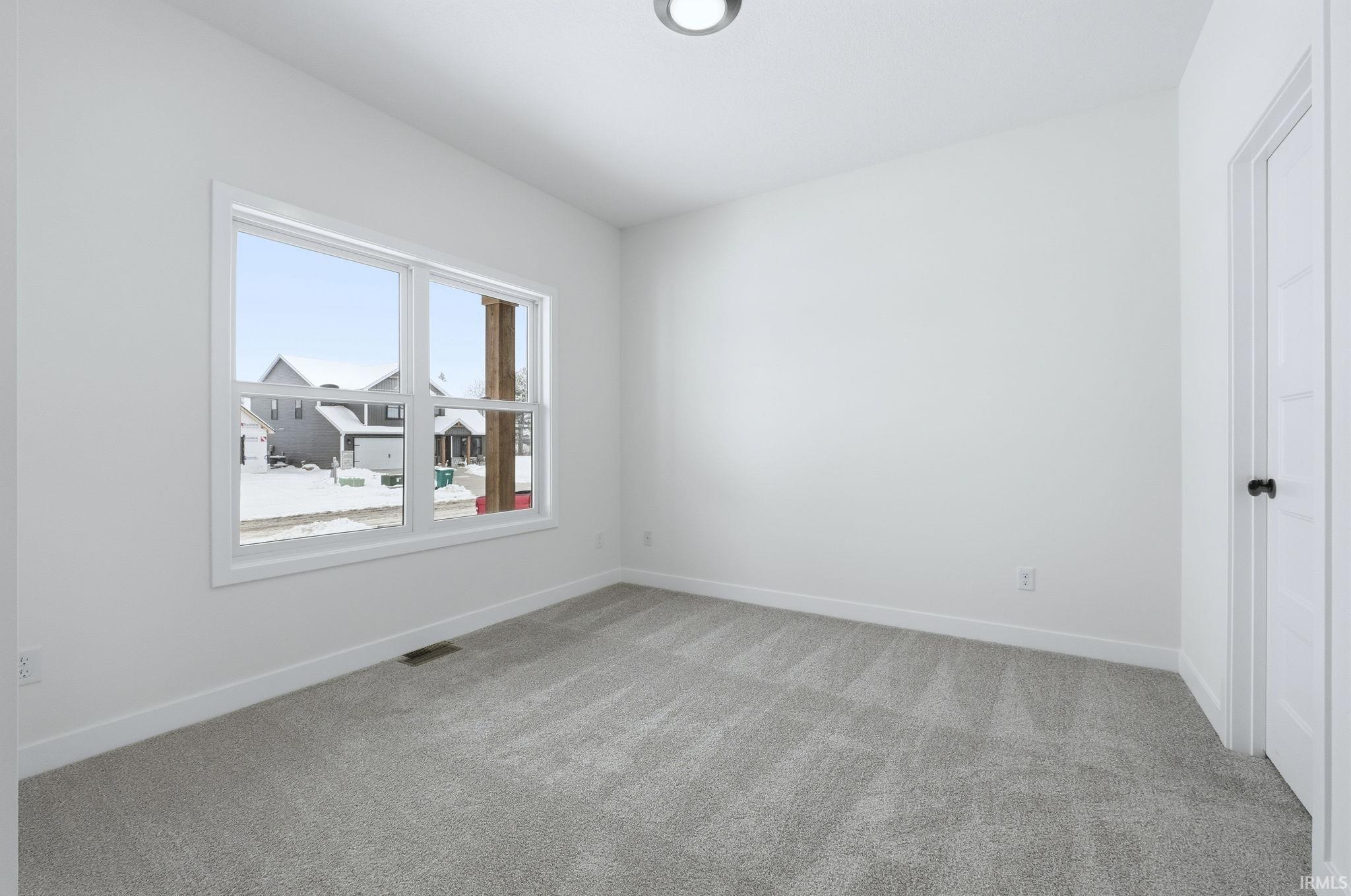 Empty room featuring carpet flooring and baseboards