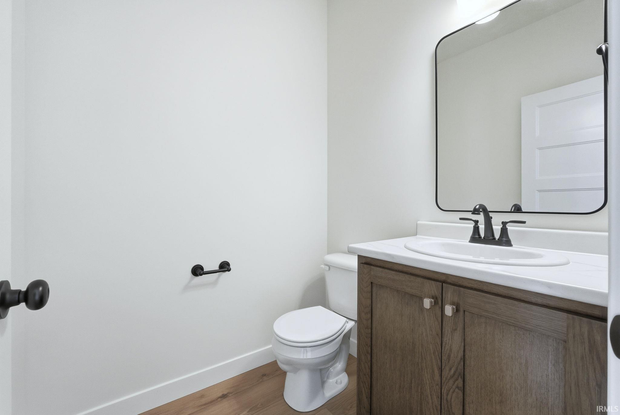 Half bath featuring vanity and light wood-style flooring