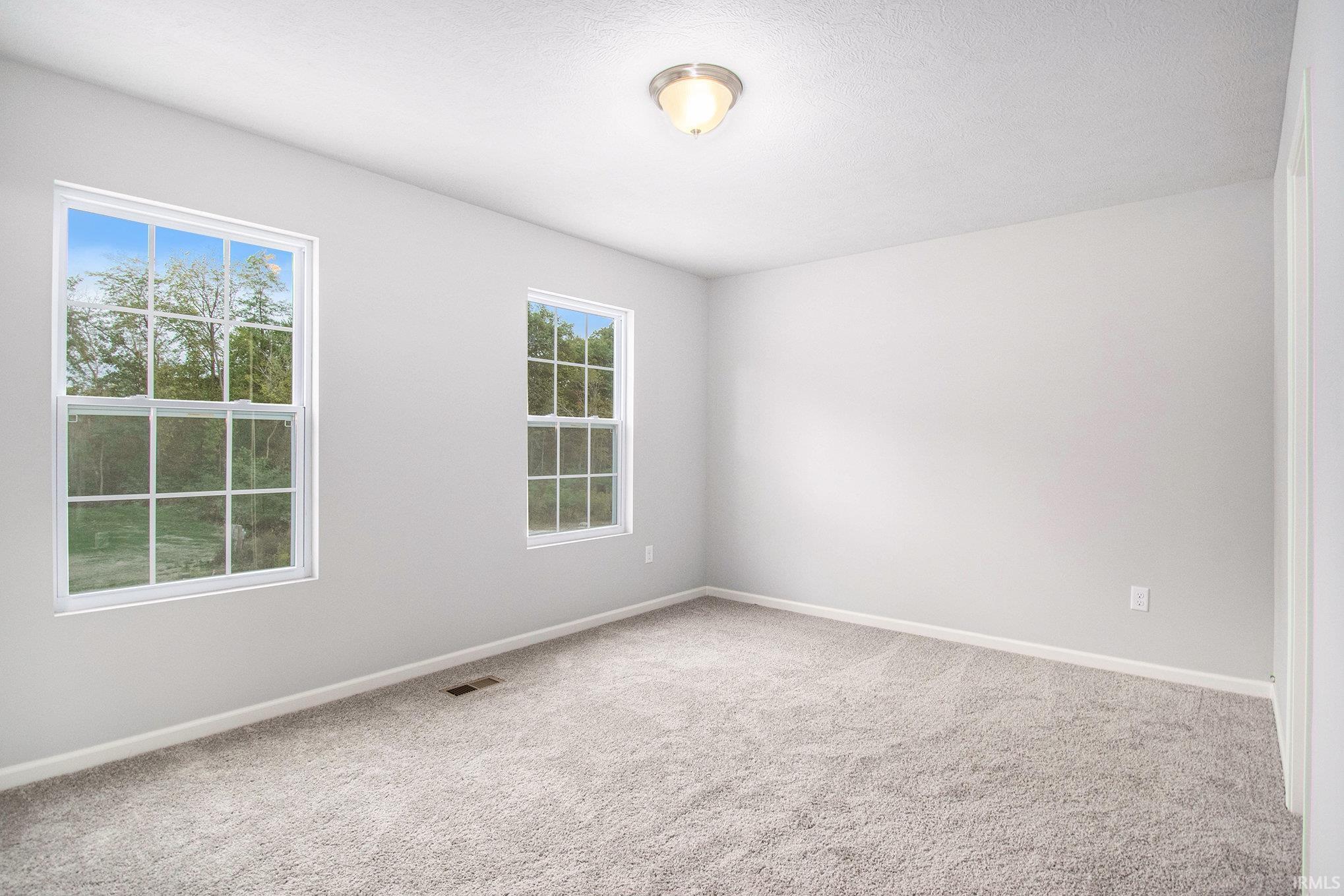 The primary suite features double exterior windows, a private bath with an exterior window and a large walk-in closet.