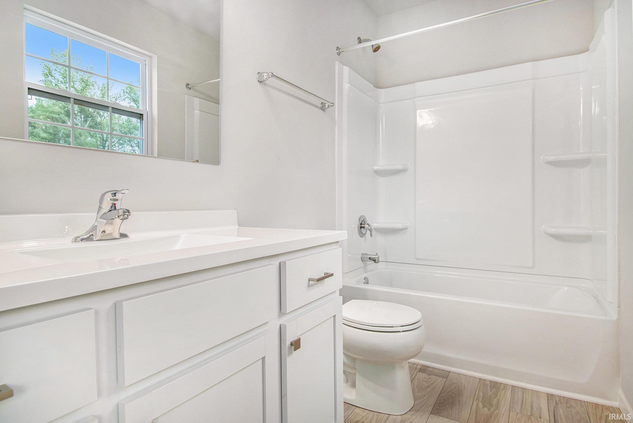 The primary suite features double exterior windows, a private bath with an exterior window and a large walk-in closet.