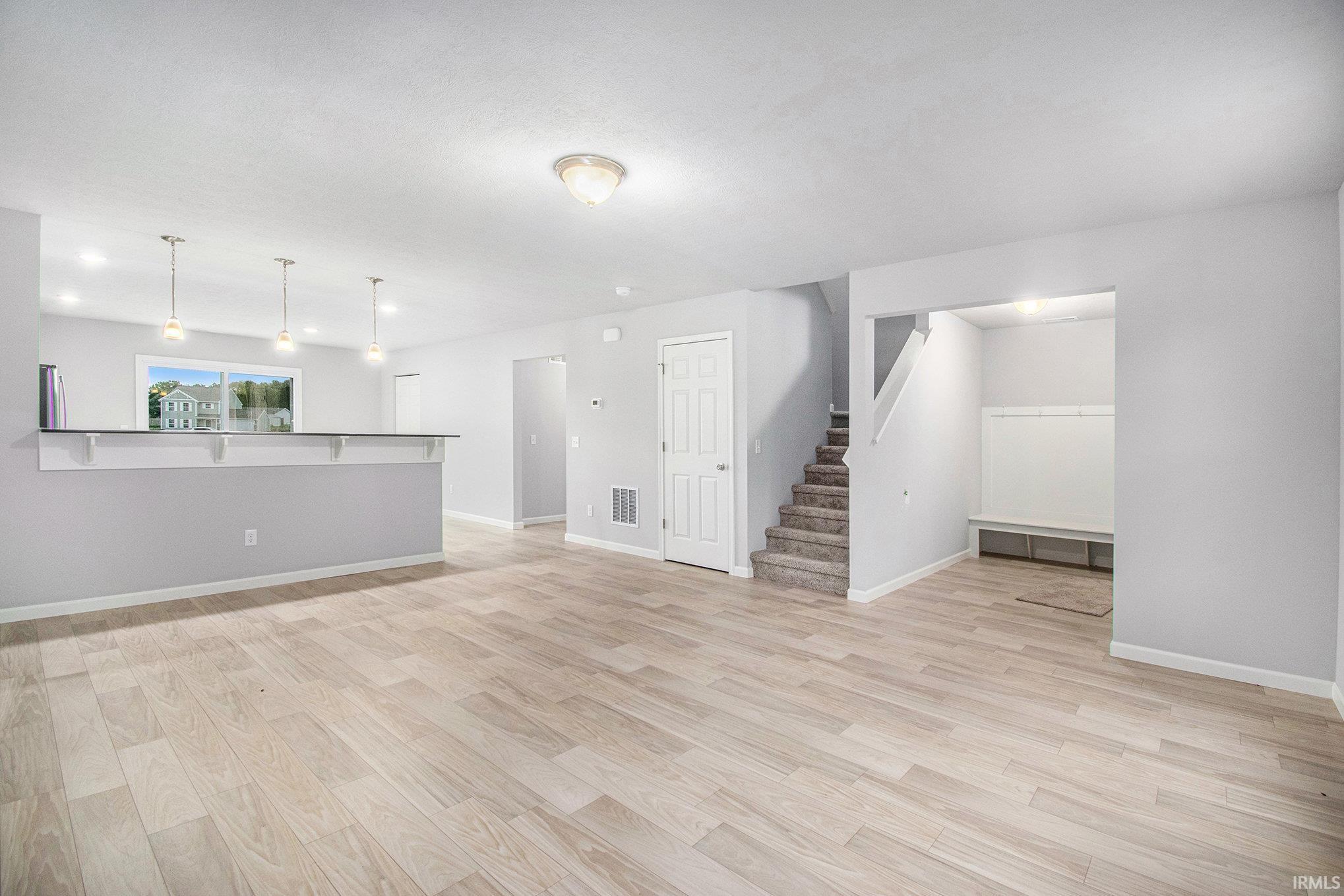 The great room flows into the kitchen, separated by a breakfast bar that can accommodate bar stools with pendant lighting above.