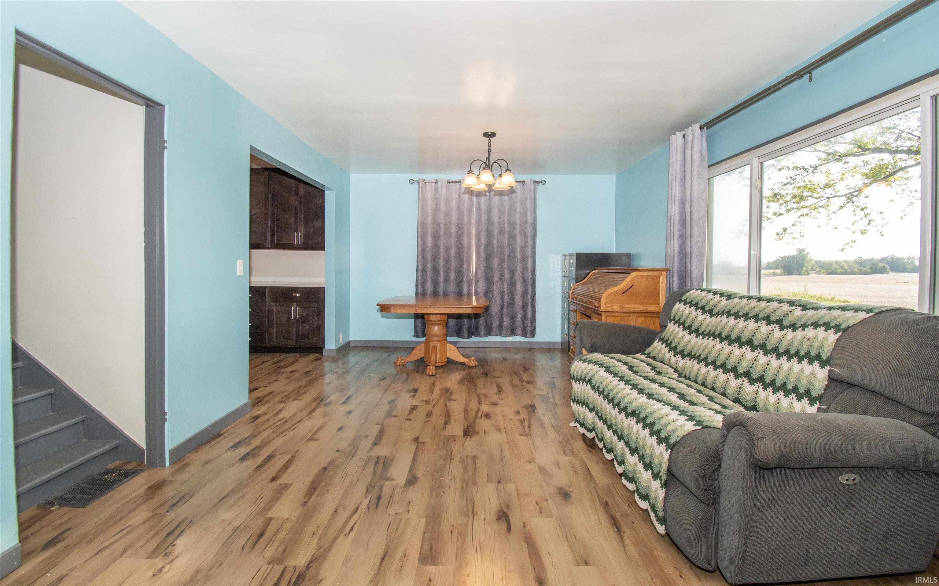 Living room with light wood finished floors and a chandelier