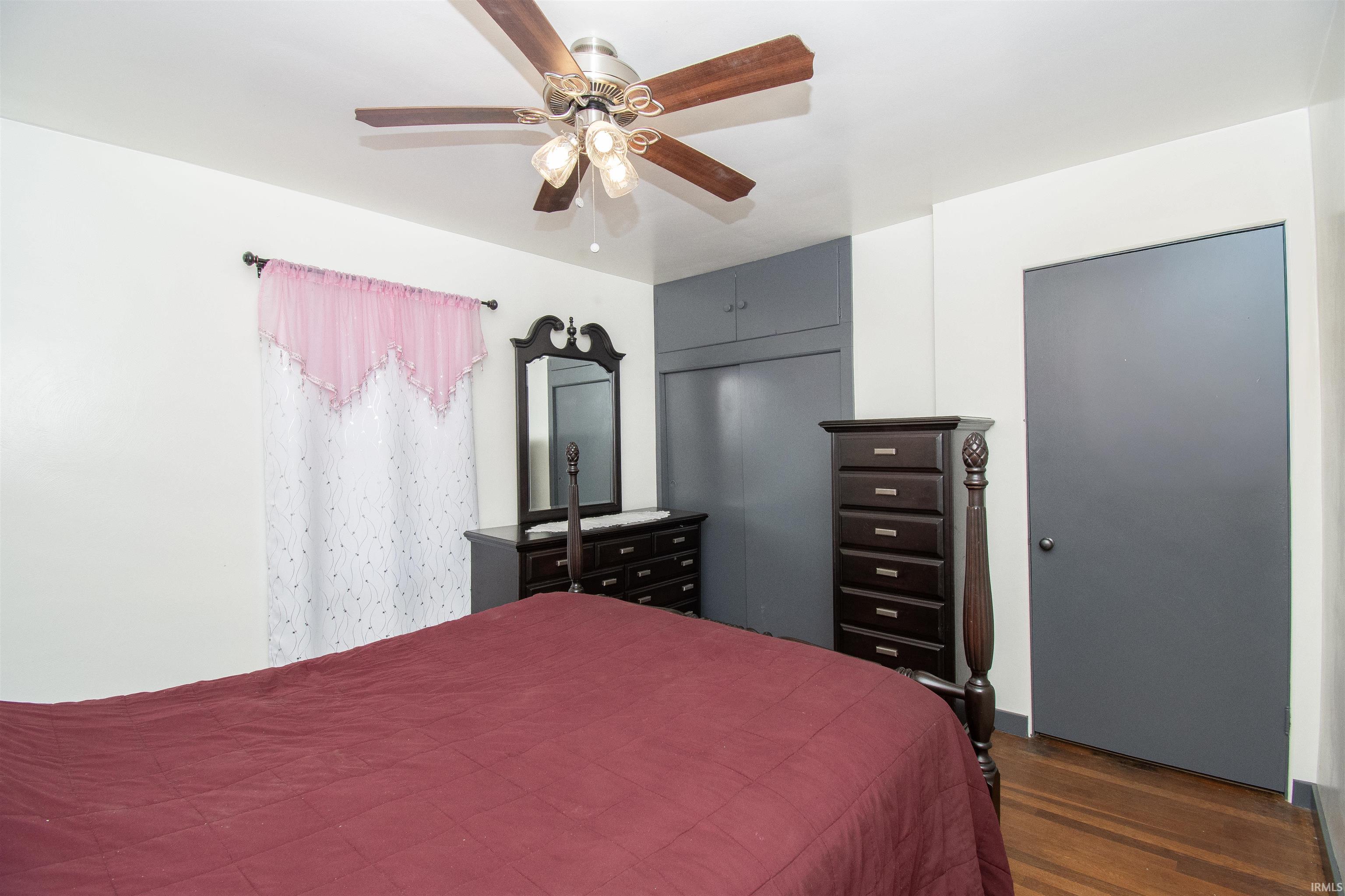Bedroom with dark wood-type flooring and ceiling fan