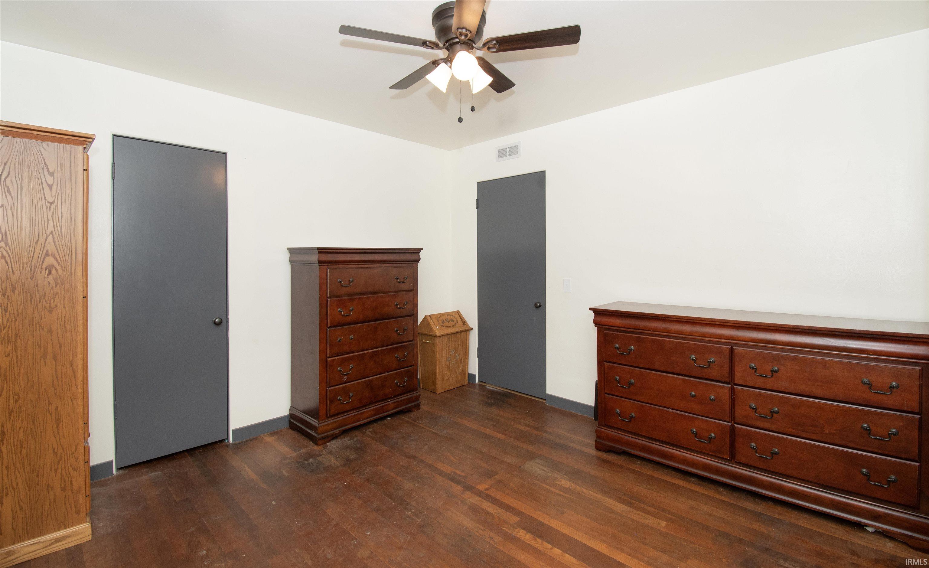 Bedroom with ceiling fan and dark wood finished floors