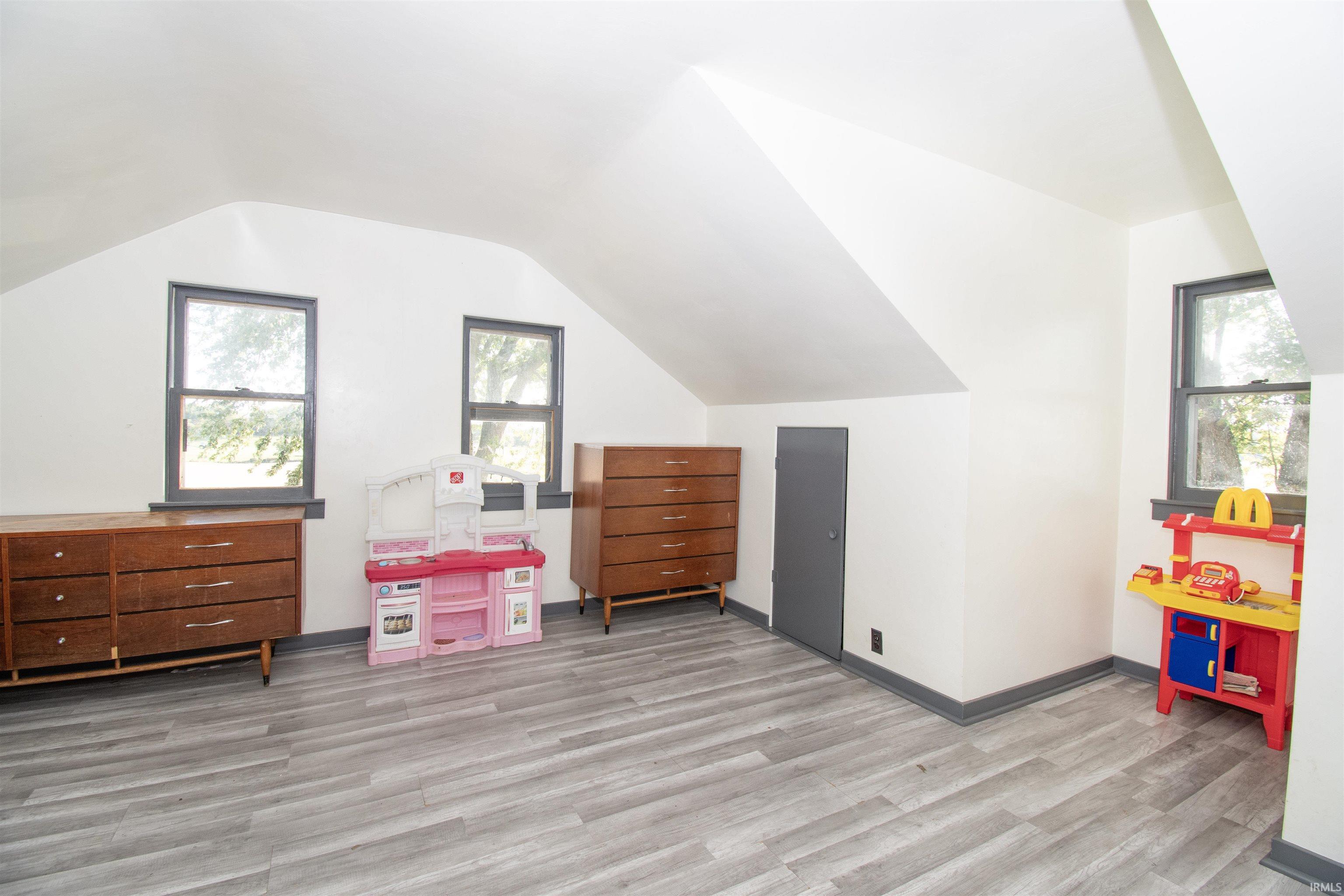 Rec room with light wood-style flooring and lofted ceiling