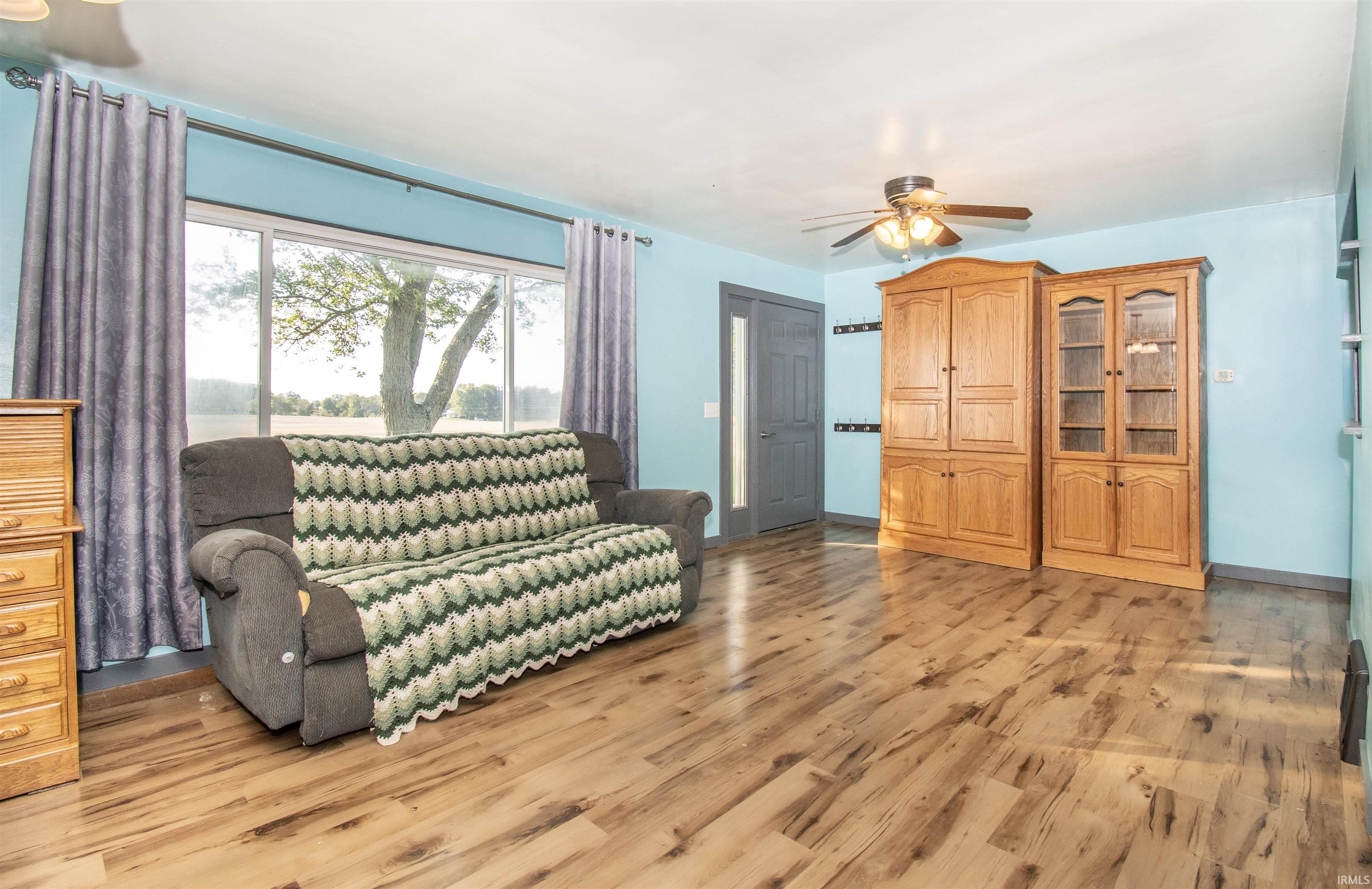 Living area featuring light wood finished floors and ceiling fan