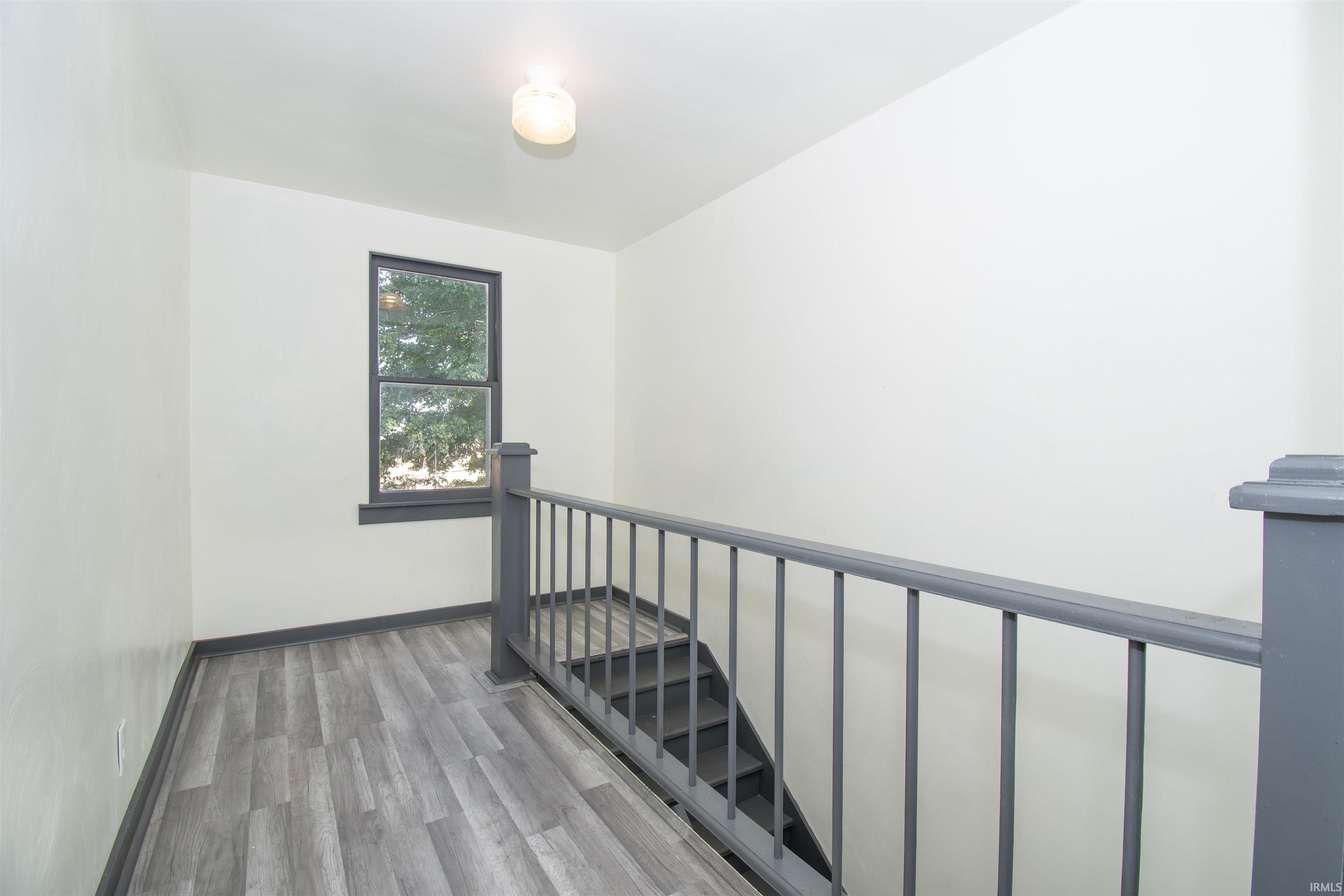 Staircase with wood finished floors and baseboards