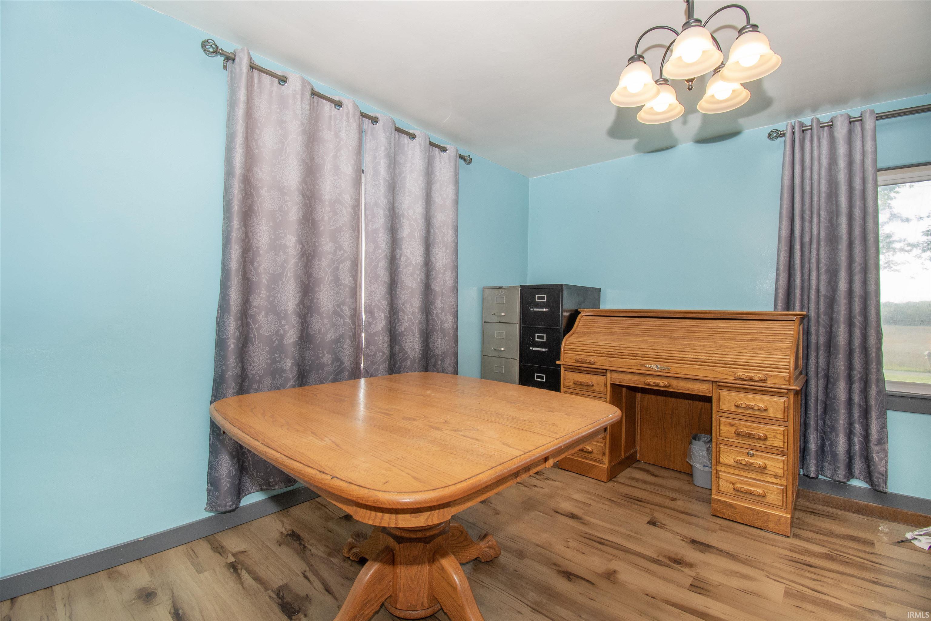 Dining room featuring a chandelier, wood finished floors, and a desk