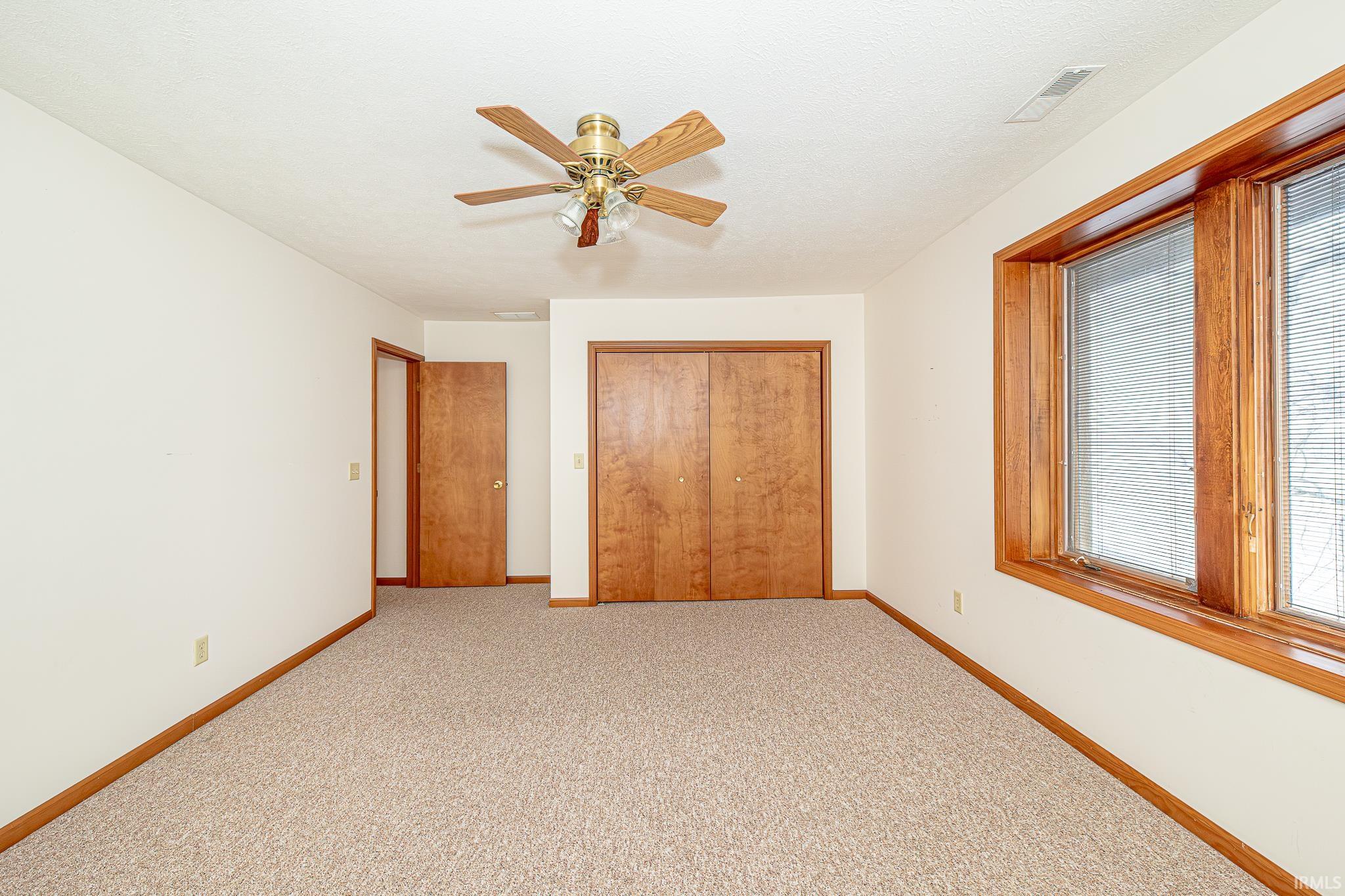 Unfurnished bedroom with carpet flooring, a closet, and ceiling fan