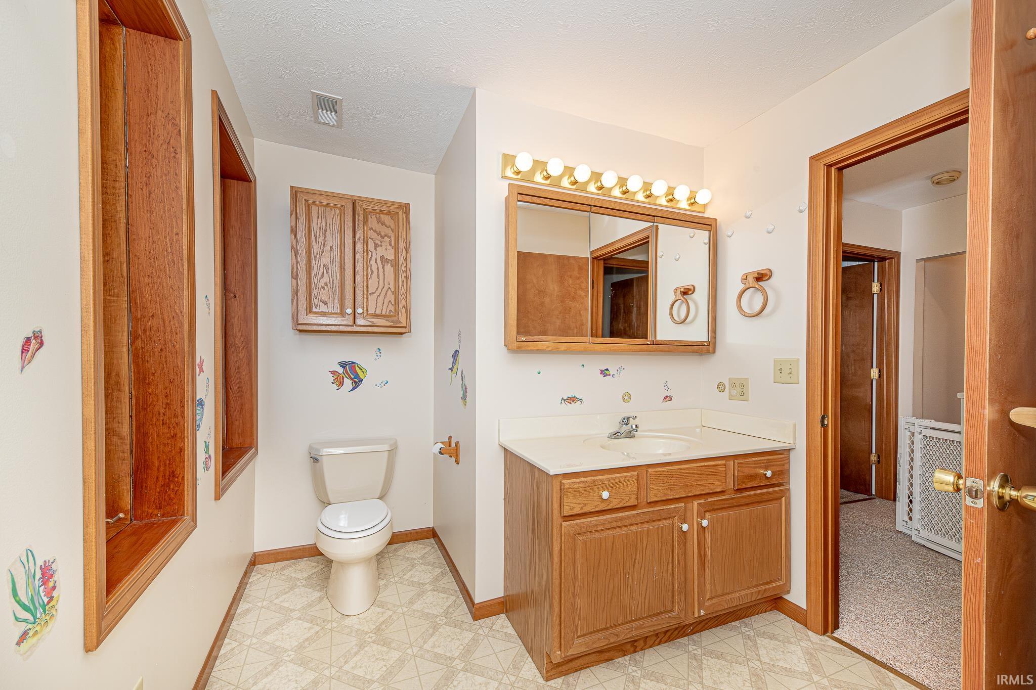 Bathroom with vanity and light flooring