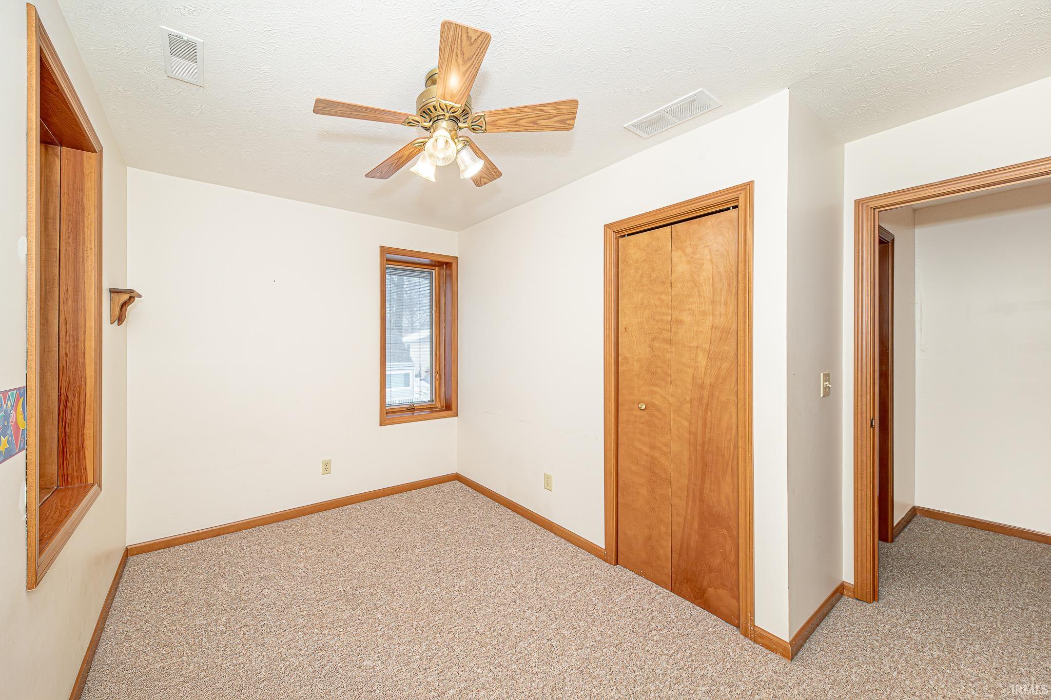 Unfurnished bedroom featuring carpet floors, a ceiling fan, a closet, and a textured ceiling