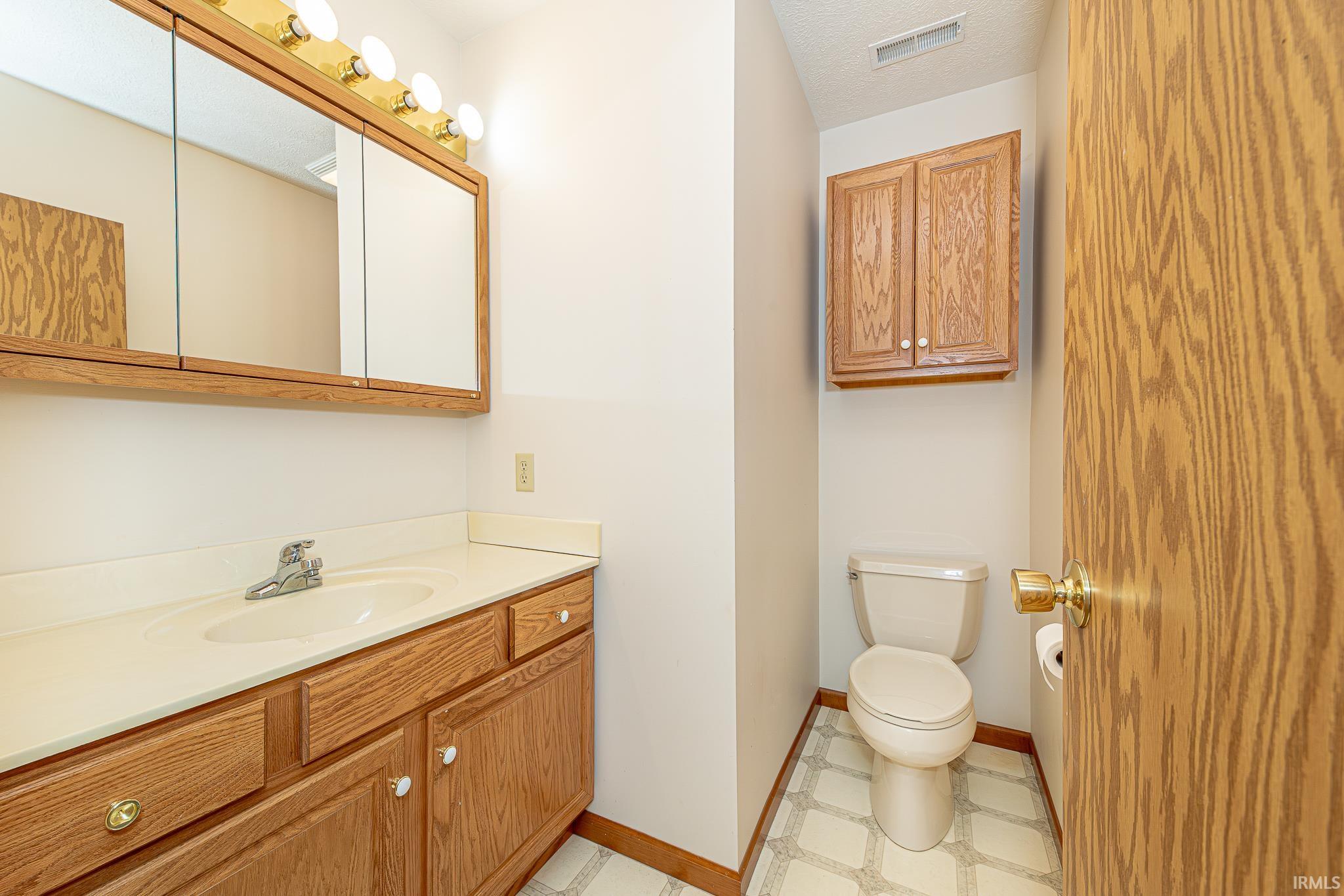 Half bath with vanity and light flooring