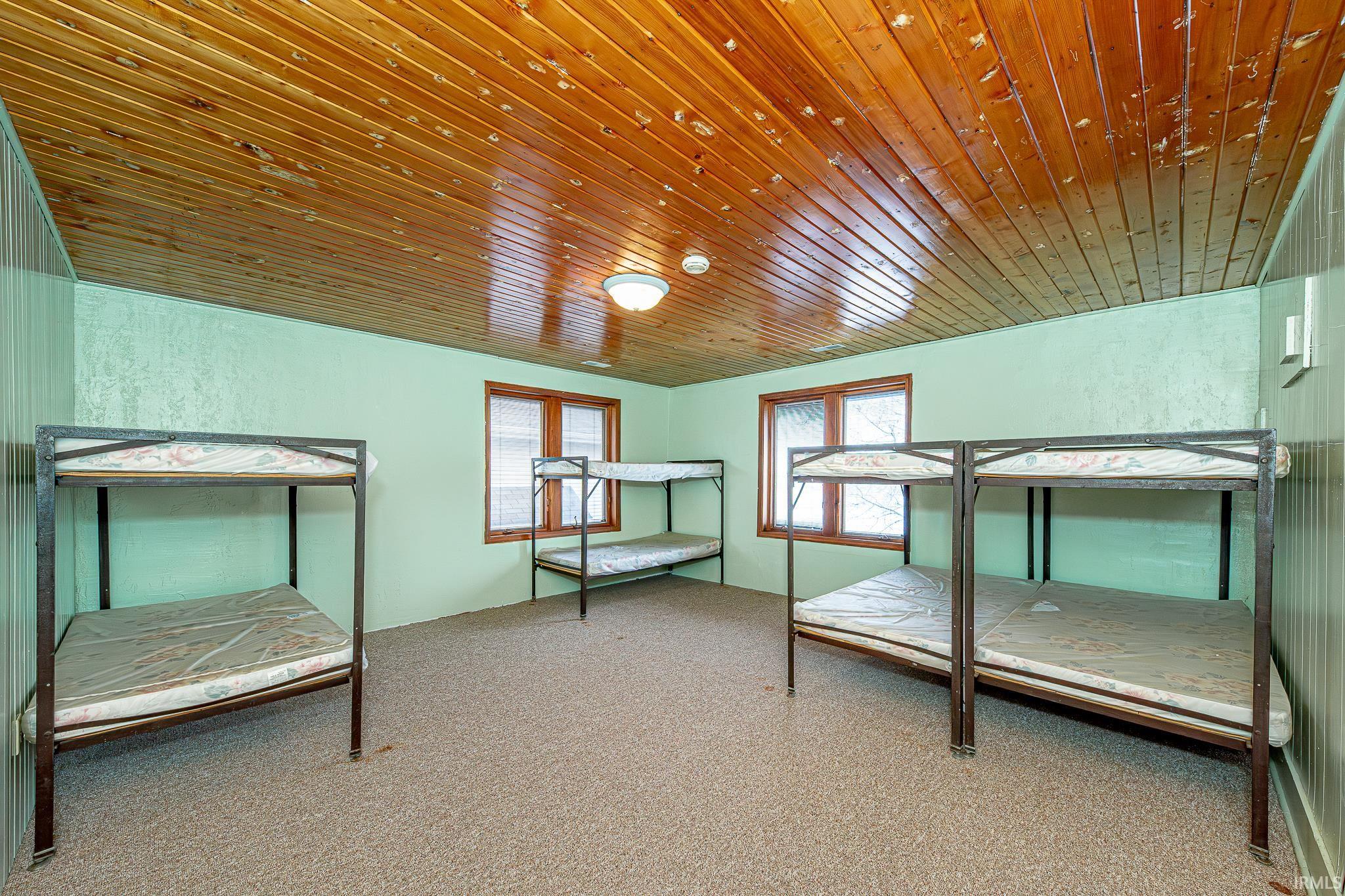 Bedroom with wood ceiling and carpet flooring
