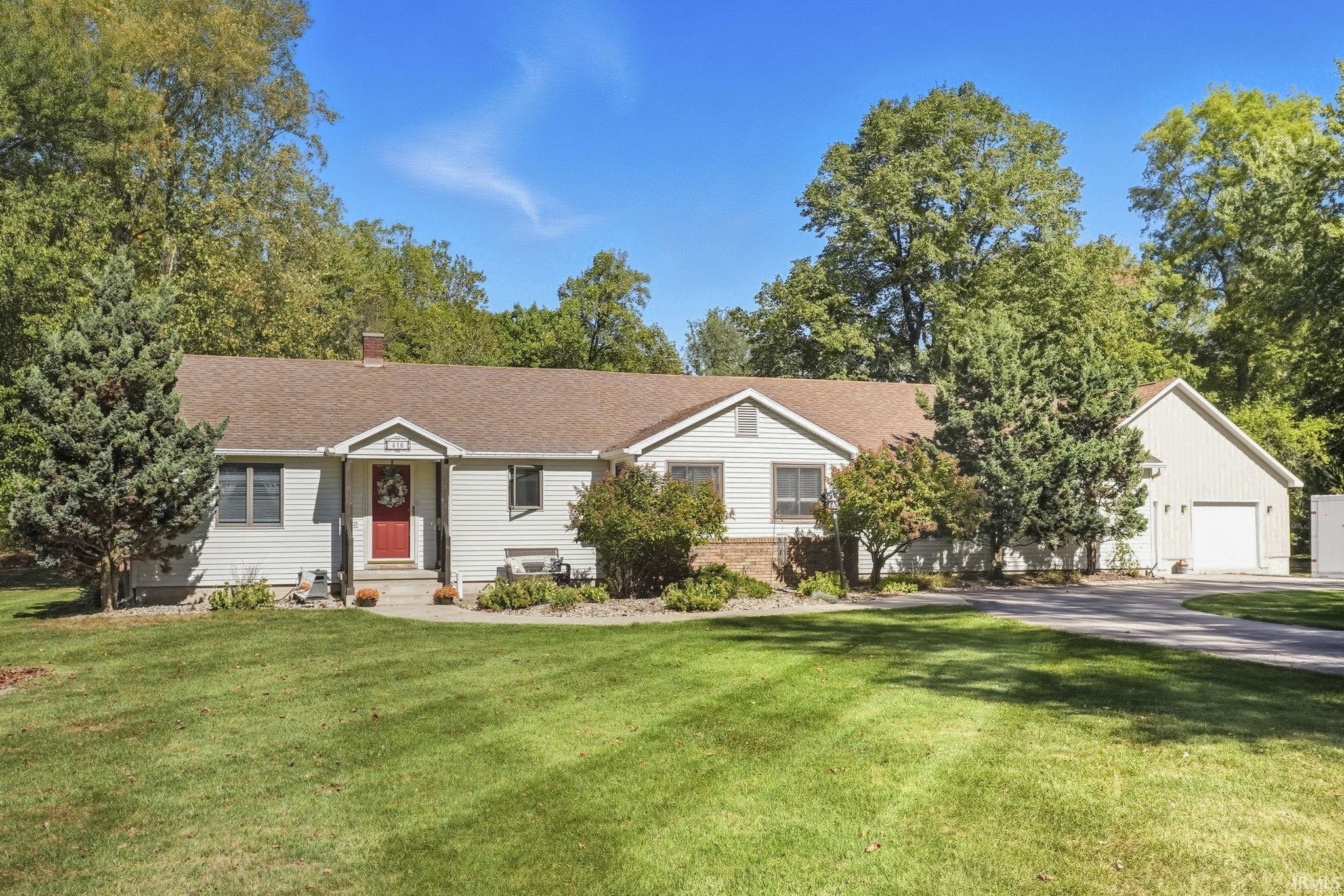 Adorable country property on 2.2 acres.  Located just a mile north of town, you will love this amazing location. Outside offers your own private oasis with a spacious yard, large patio for entertaining, and above ground pool fully surrounded by pool deck — all overlooking a beautiful wooded backdrop! If you need garage/workshop space, there is a 30x34 outbuilding built in 2016 with cement floor, workshop area, and recreation space, along with an attached garage and storage shed. Inside the home offers bright natural light and the perfect amount of space. Home features 3 bedrooms, 2 full baths, cozy living room with wood plank flooring, updated main floor laundry room, a large dining room big enough for farmhouse table, and a basement with small finished area and tons of storage space! This type of property is hard to come by, be sure to check it out!