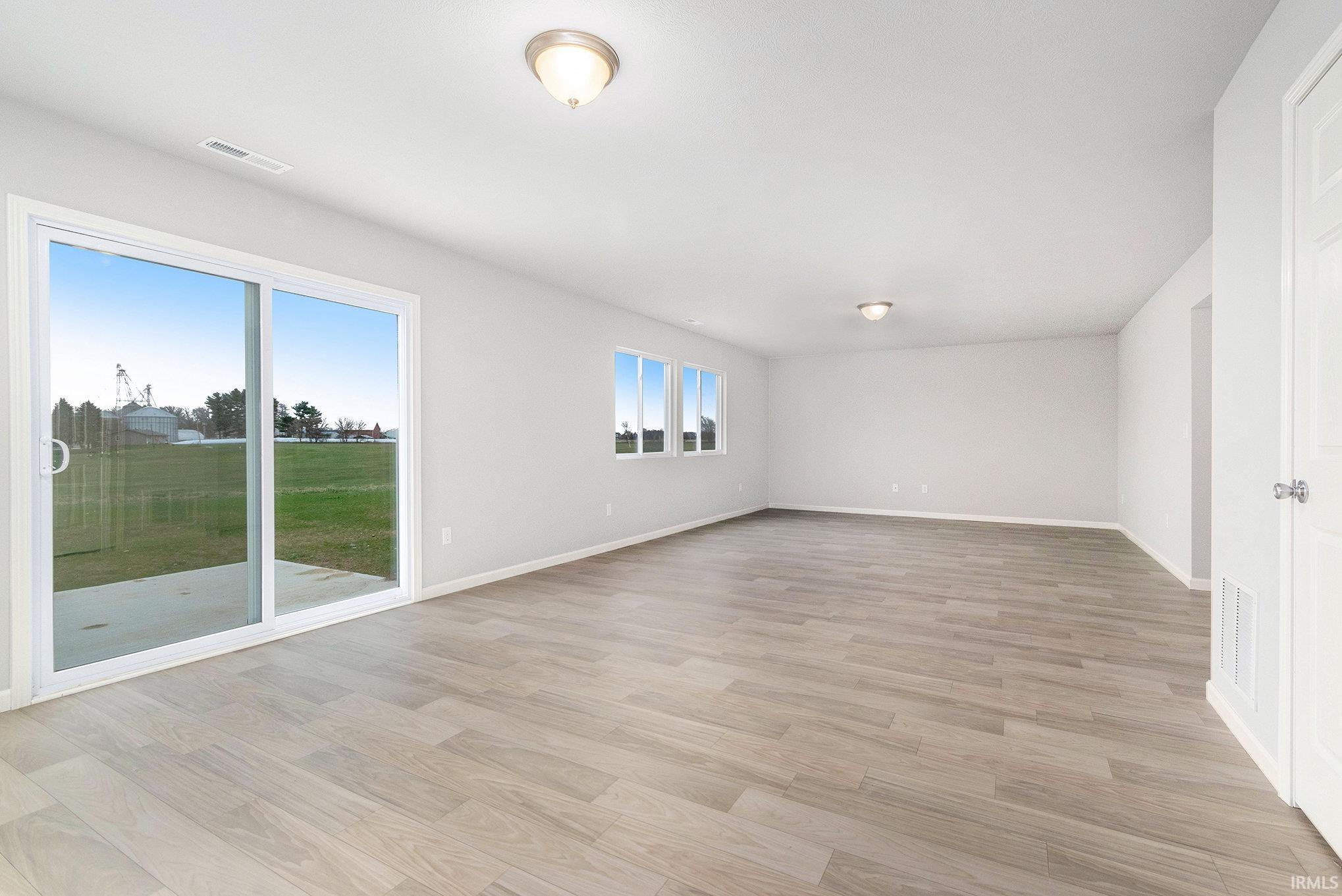 The massive great room features multiple windows on 2 sides and open sight lines to the nook & kitchen with consistent flooring for cohesive transitions.