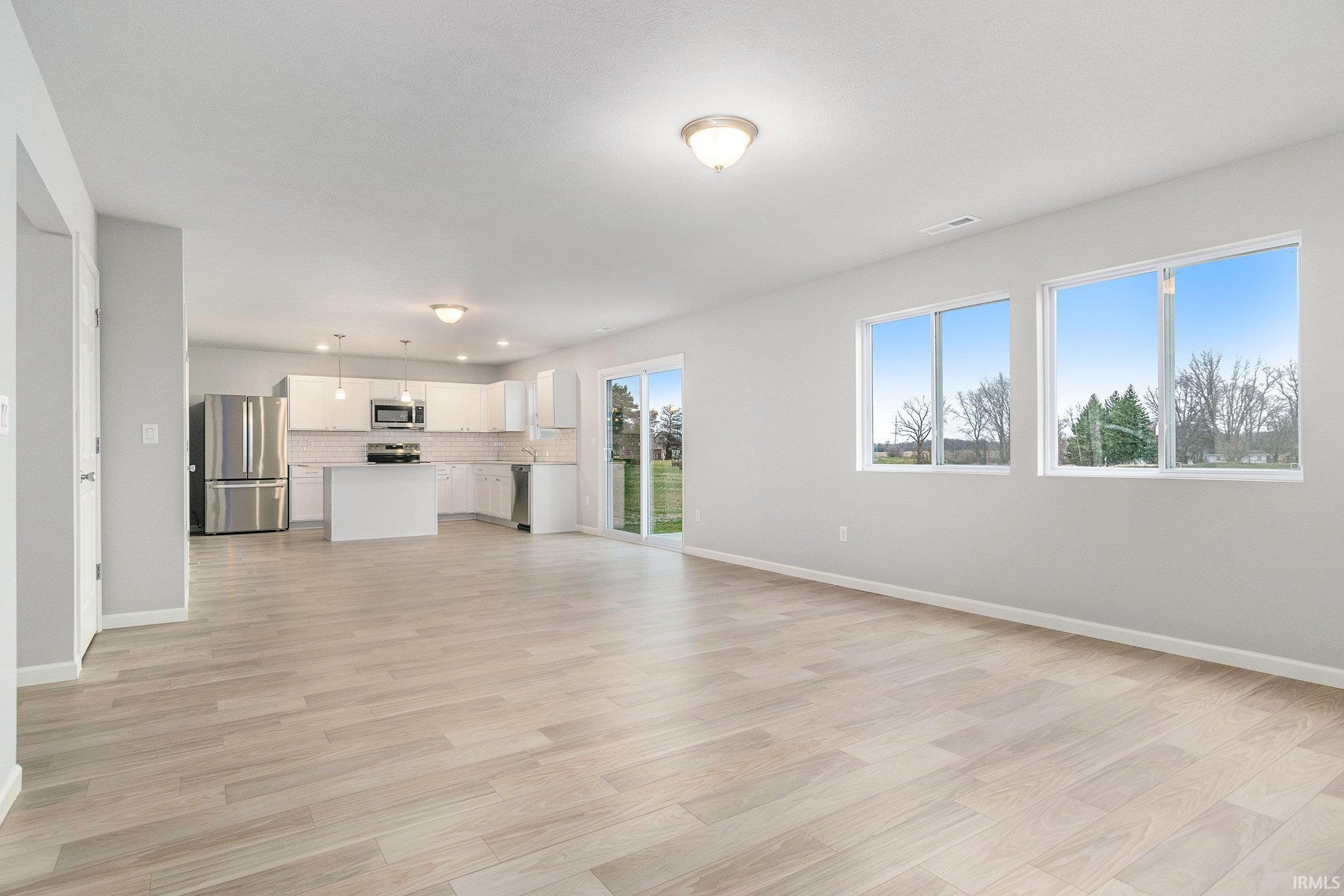 The massive great room features multiple windows on 2 sides and open sight lines to the nook & kitchen with consistent flooring for cohesive transitions.