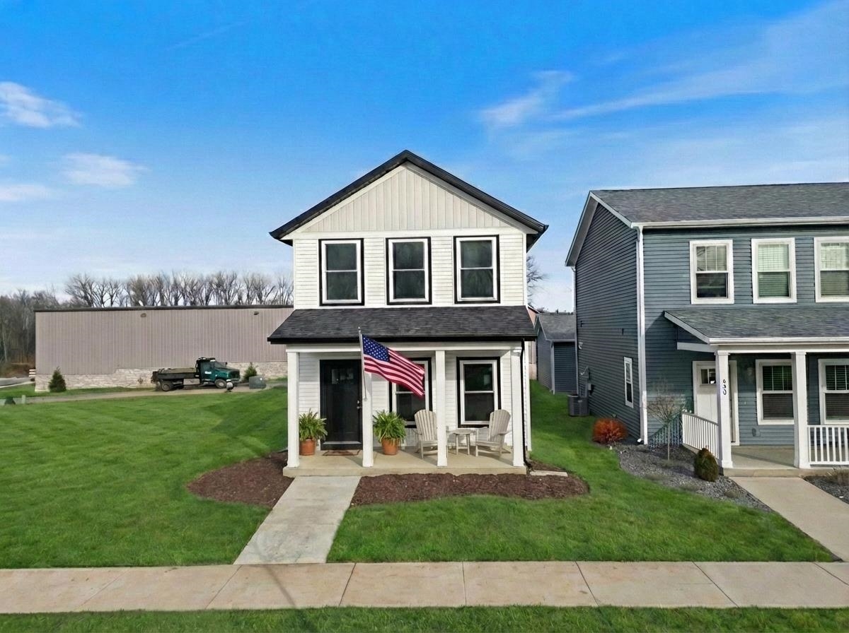 Traditional-style home featuring covered porch, roof with shingles, and driveway